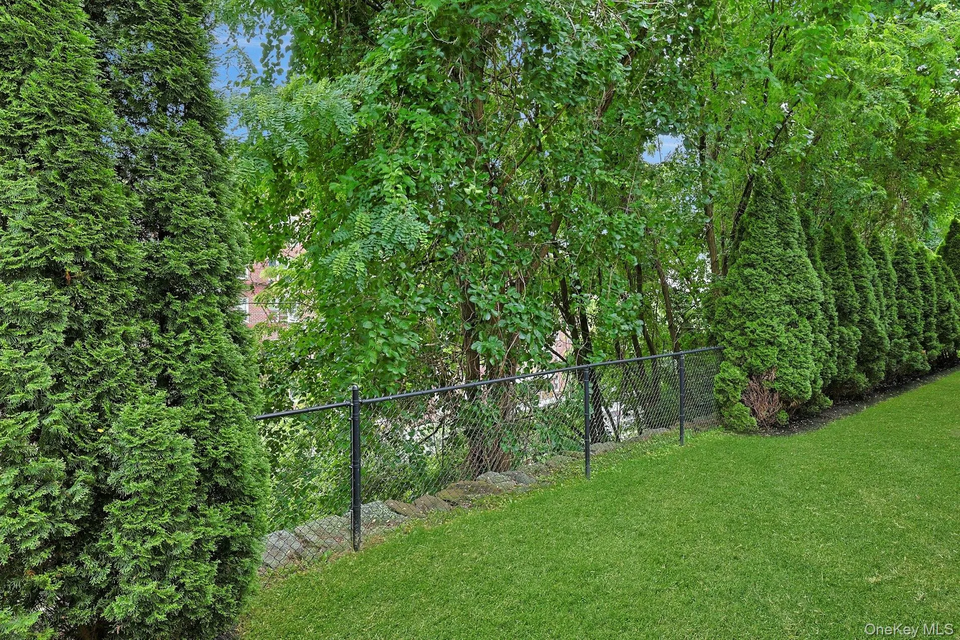 Surrounded by mature evergreens for privacy, the backyard provides a beautiful outdoor setting with level lawn space for recreation, pets, and play. Surrounded by mature evergreens for privacy, the backyard provides a beautiful outdoor setting with level lawn space for recreation, pets, and play.