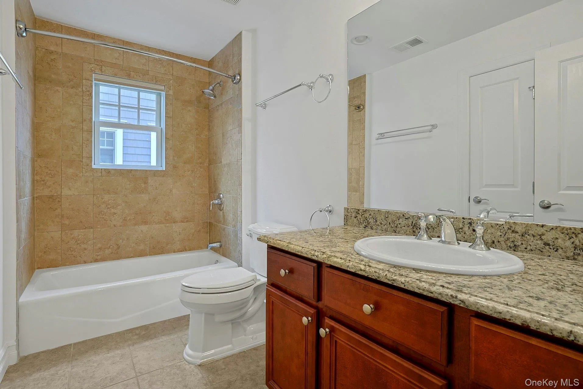 The beautifully appointed hall bath features a granite-topped vanity, warm stone tile, and a full tub/shower combination, blending style and functionality for everyday living. The beautifully appointed hall bath features a granite-topped vanity, warm stone tile, and a full tub/shower combination, blending style and functionality for everyday living.