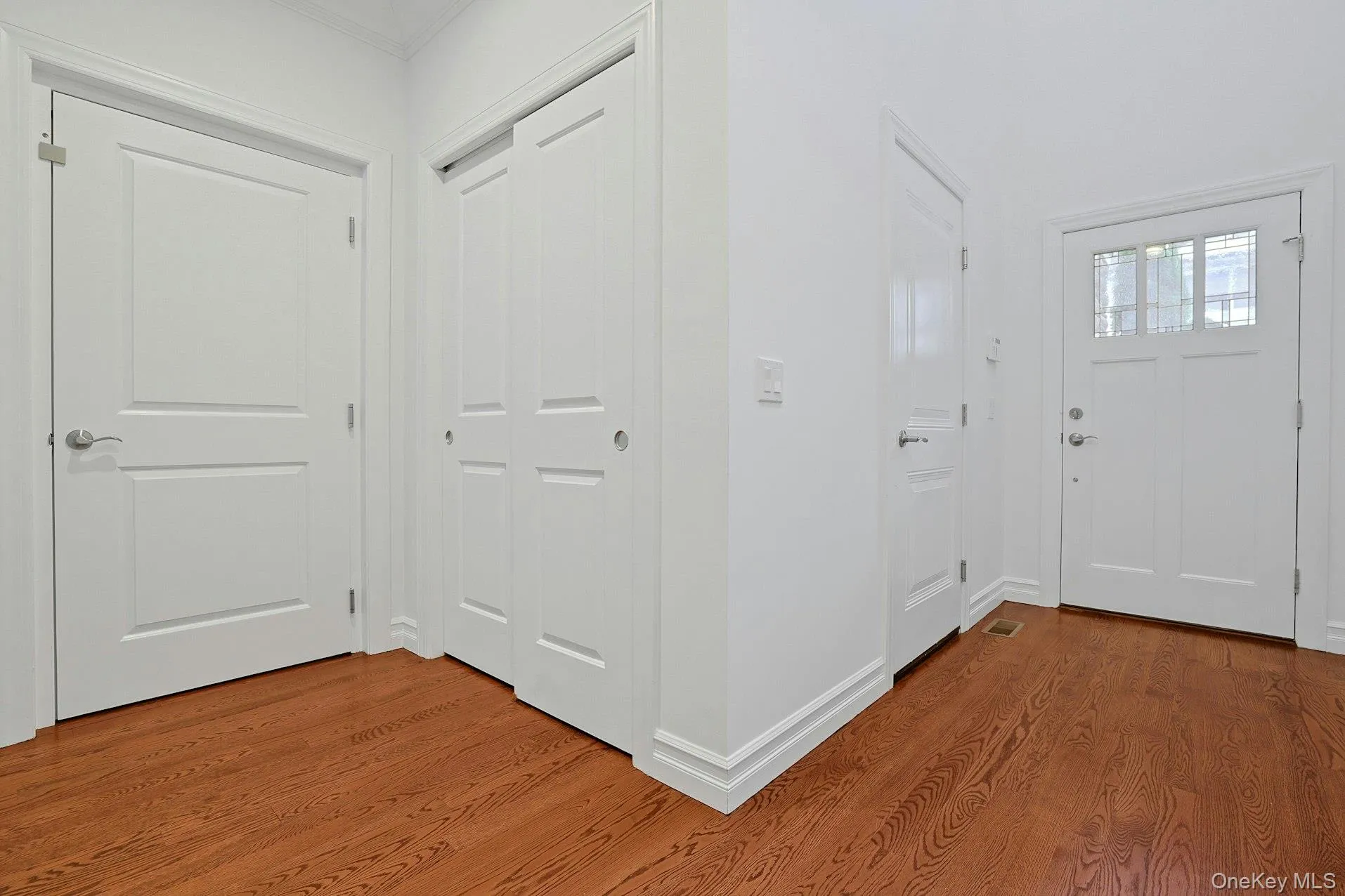 A welcoming entry with hardwood floors, generous coat closet space, powder room, and two-car garage access. A welcoming entry with hardwood floors, generous coat closet space, powder room, and two-car garage access.