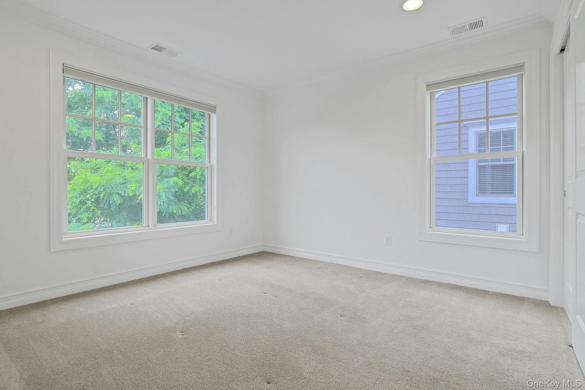A bright and spacious bedroom featuring oversized windows, plush carpeting, and generous closet space, creating a comfortable retreat for family or guests. A bright and spacious bedroom featuring oversized windows, plush carpeting, and generous closet space, creating a comfortable retreat for family or guests.