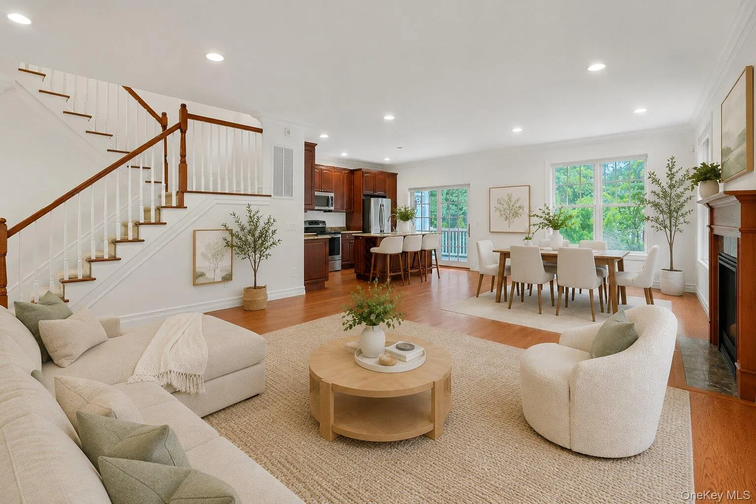 Sun-filled and spacious, the main level is designed for modern living with oversized windows, hardwood floors, a gas fireplace, and seamless flow between living, dining, and kitchen spaces. (Digitally staged) Sun-filled and spacious, the main level is designed for modern living with oversized windows, hardwood floors, a gas fireplace, and seamless flow between living, dining, and kitchen spaces. (Digitally staged)