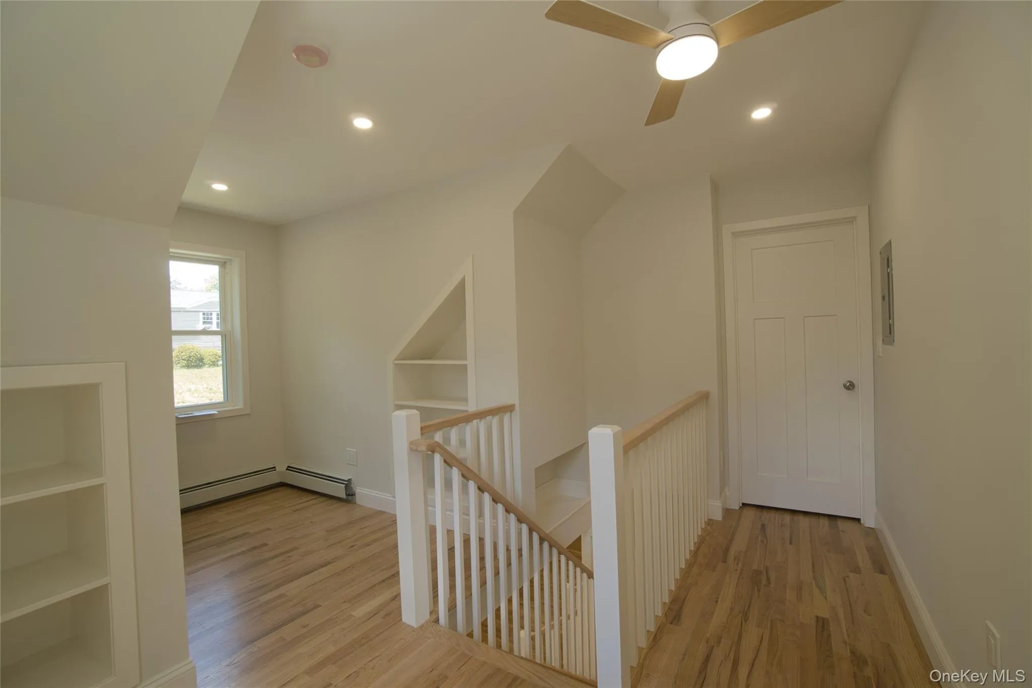 Upper-level hallway featuring wood-finish flooring, recessed lighting, and a modern ceiling fan Upper-level hallway featuring wood-finish flooring, recessed lighting, and a modern ceiling fan
