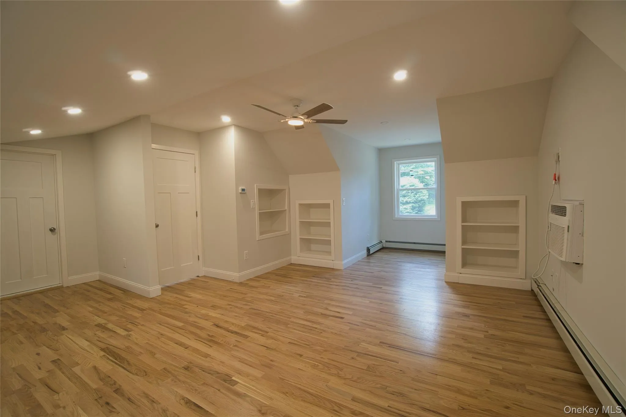 Spacious room featuring wood-finish flooring, recessed lighting, and a ceiling fan Spacious room featuring wood-finish flooring, recessed lighting, and a ceiling fan