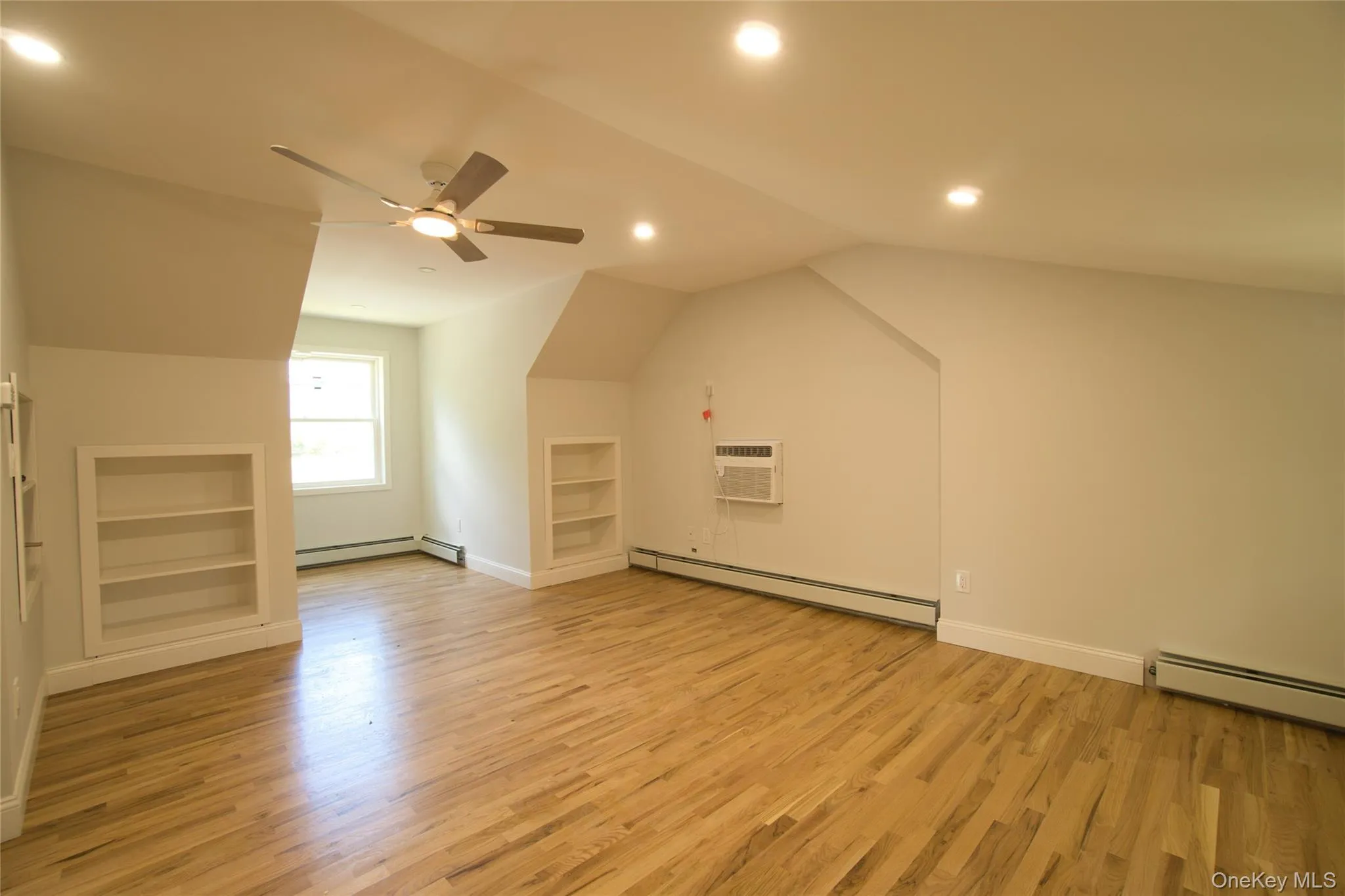Spacious room featuring wood-finish flooring, recessed lighting, and a ceiling fan Spacious room featuring wood-finish flooring, recessed lighting, and a ceiling fan