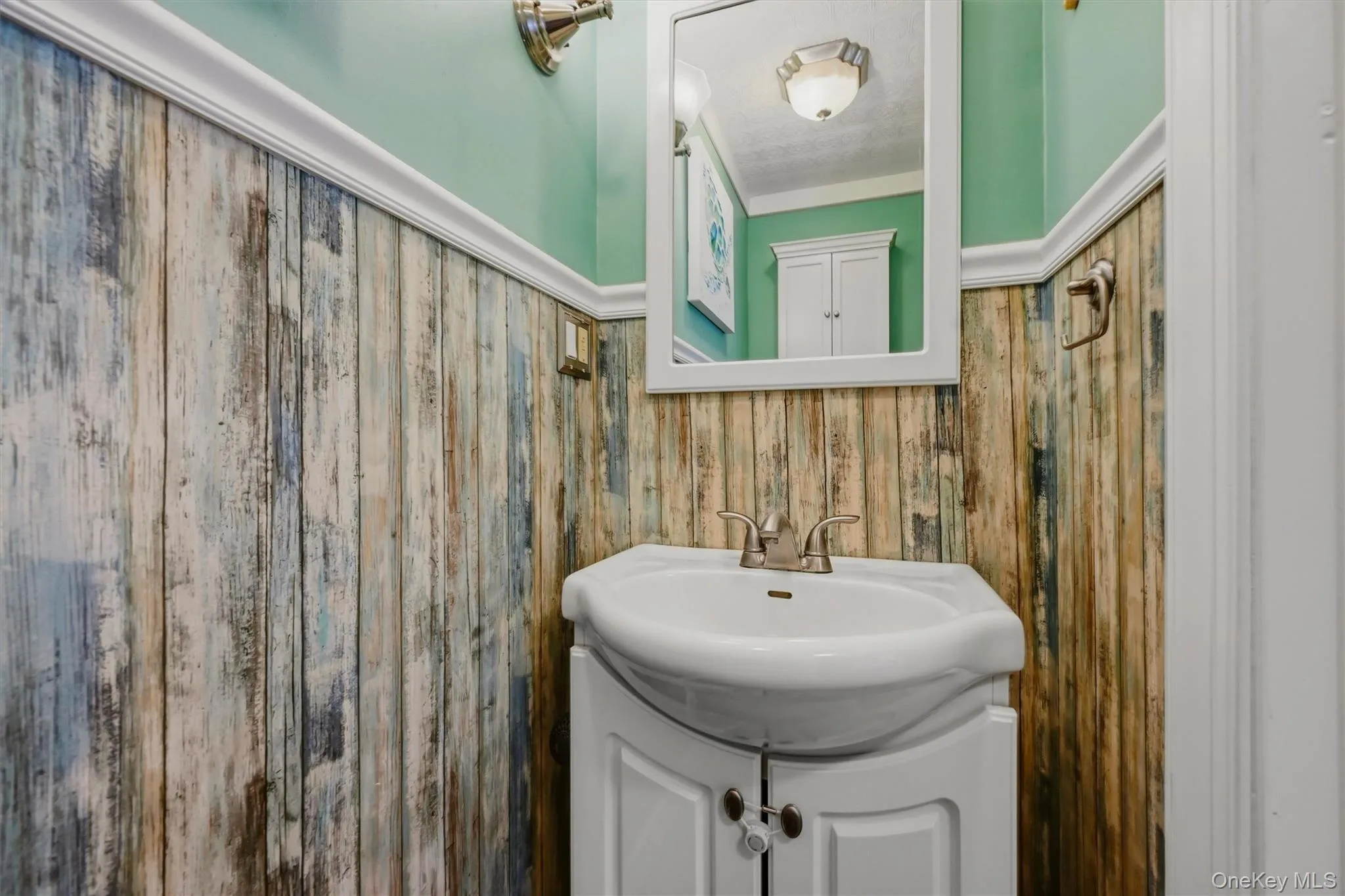 Pedestal sink with a white vanity cabinet and brushed nickel faucet Pedestal sink with a white vanity cabinet and brushed nickel faucet