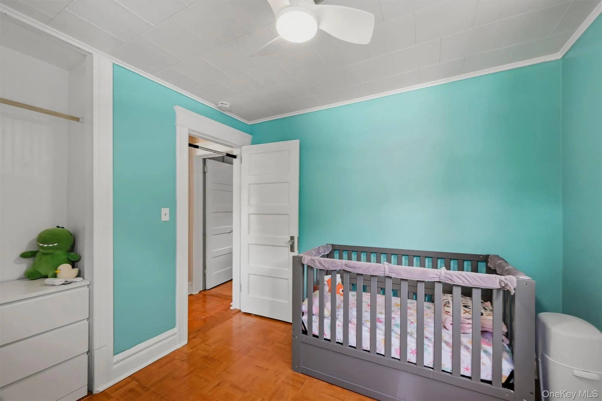 Room with wood-finish flooring, white trim, and a ceiling fan Room with wood-finish flooring, white trim, and a ceiling fan