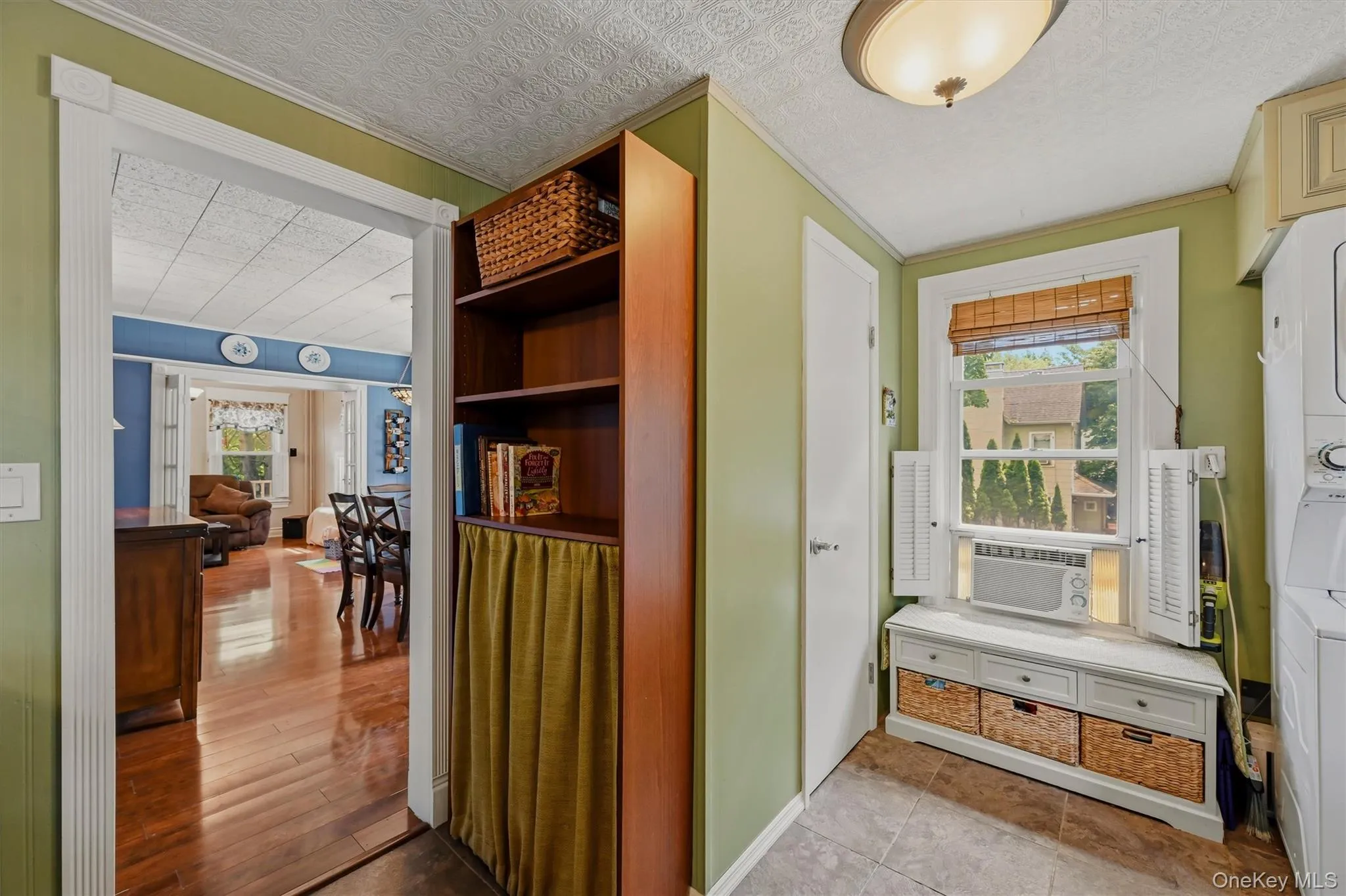 Convenient mudroom/laundry area with tile flooring, built-in storage, and charming ceiling detail. Flows easily into the main living spaces with hardwood floors and classic trim. Convenient mudroom/laundry area with tile flooring, built-in storage, and charming ceiling detail. Flows easily into the main living spaces with hardwood floors and classic trim.