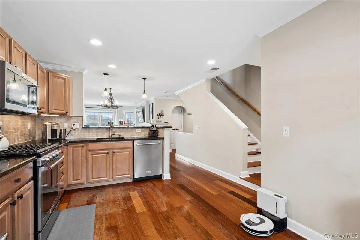 Kitchen featuring wood-finish flooring, light wood cabinetry, stainless steel appliances, granite countertops Kitchen featuring wood-finish flooring, light wood cabinetry, stainless steel appliances, granite countertops