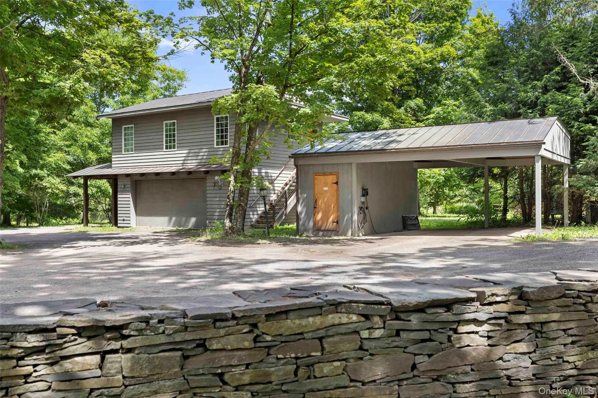 Detached garage with one-bedroom apartment above, covered carport, and EV charging station Detached garage with one-bedroom apartment above, covered carport, and EV charging station