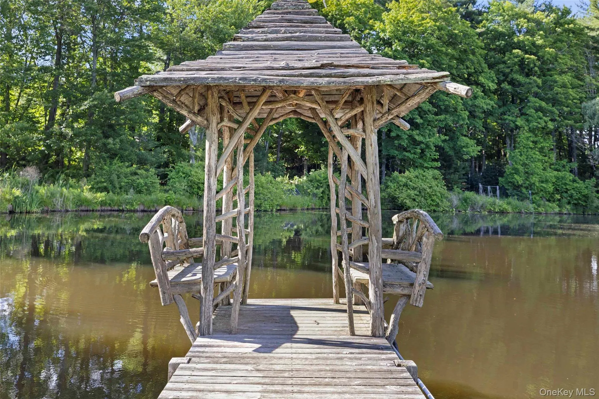 A hand-crafted pond pavilion overlooking the spring-fed pond, offering a secluded place to relax and take in the landscape A hand-crafted pond pavilion overlooking the spring-fed pond, offering a secluded place to relax and take in the landscape