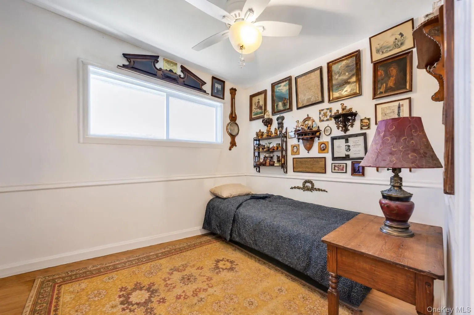 Room featuring wood-finish flooring, a ceiling fan with integrated lighting, and a white window with a valance Room featuring wood-finish flooring, a ceiling fan with integrated lighting, and a white window with a valance