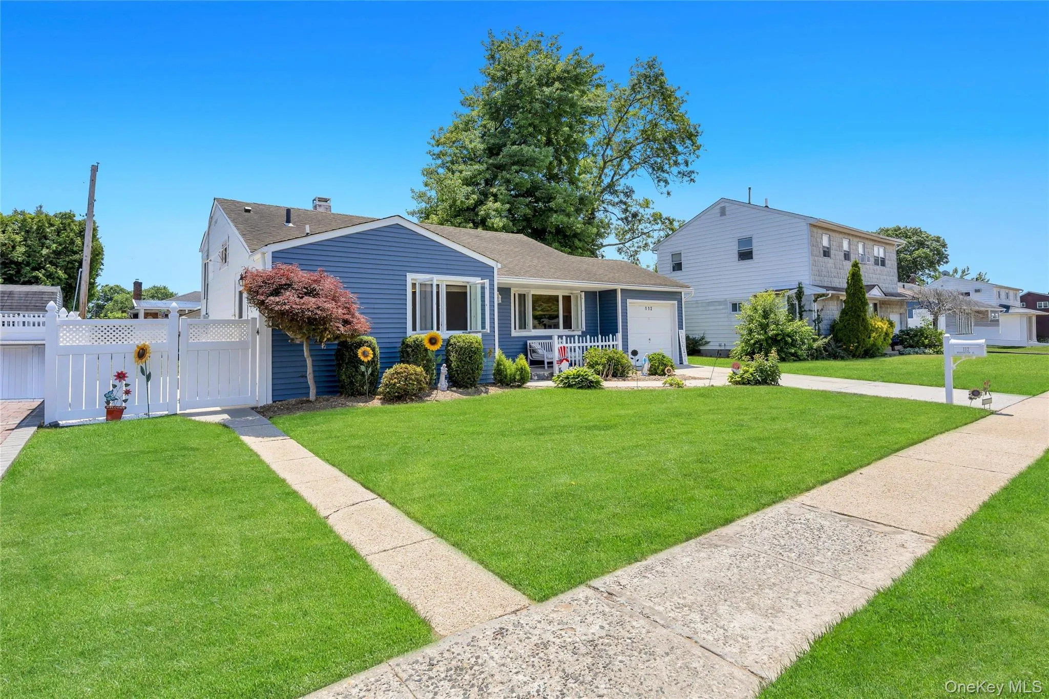 Blue siding exterior featuring white trim and a single-car garage Blue siding exterior featuring white trim and a single-car garage