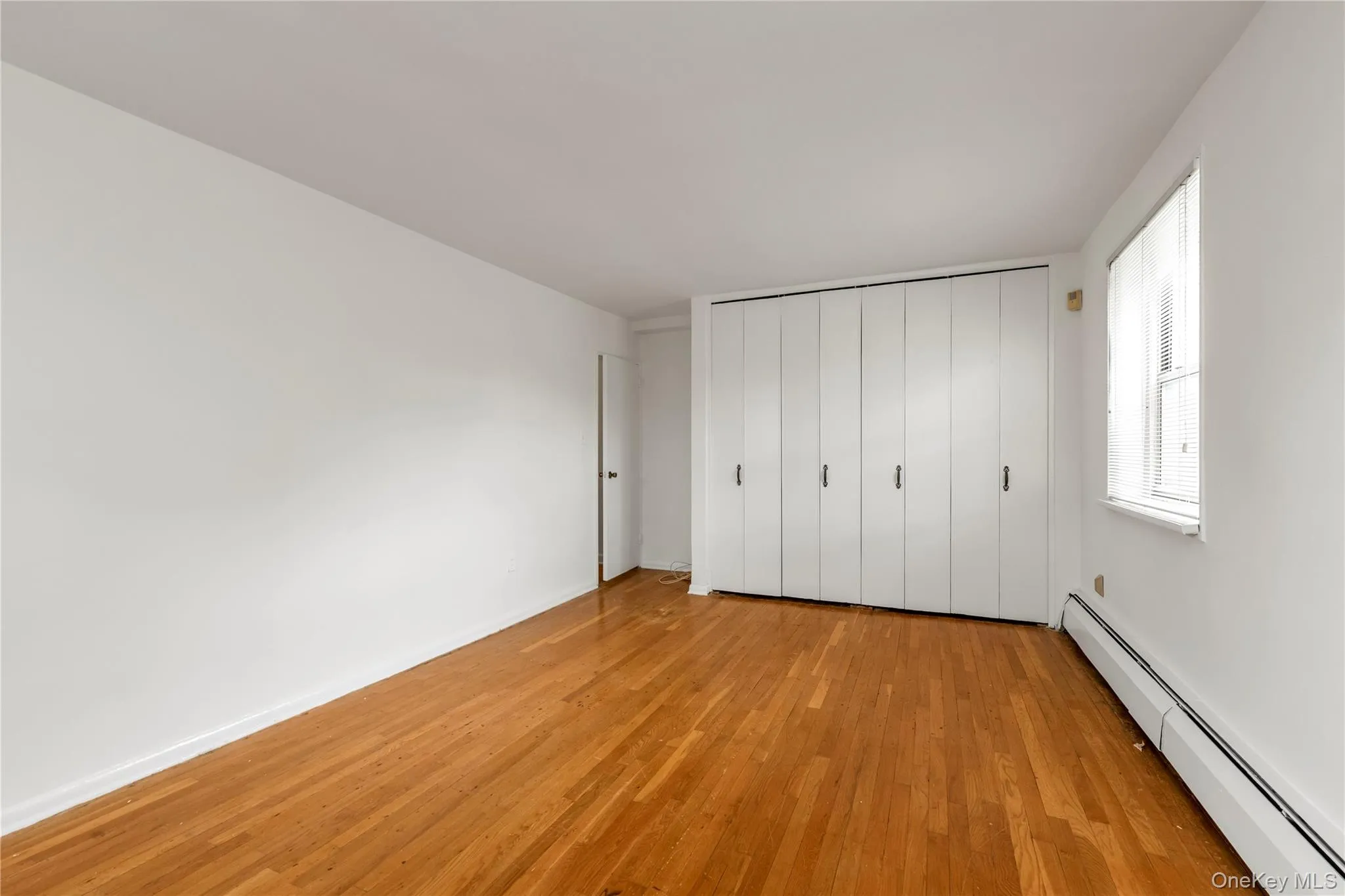 Primary Bedroom with Hardwood Floors & Double Closets Primary Bedroom with Hardwood Floors & Double Closets