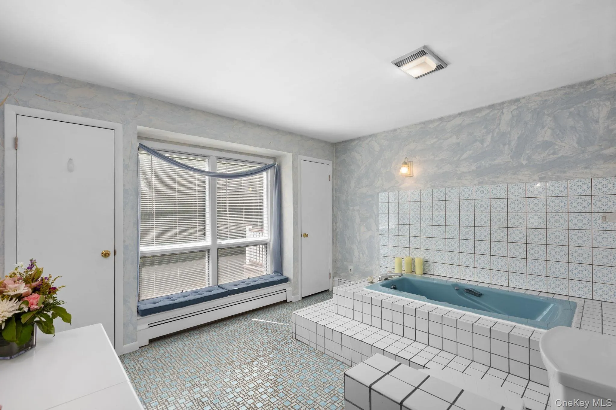 En-Suite bathroom with a clue spa tub, blue/white pattern floor tiles, vanity and closet. En-Suite bathroom with a clue spa tub, blue/white pattern floor tiles, vanity and closet.