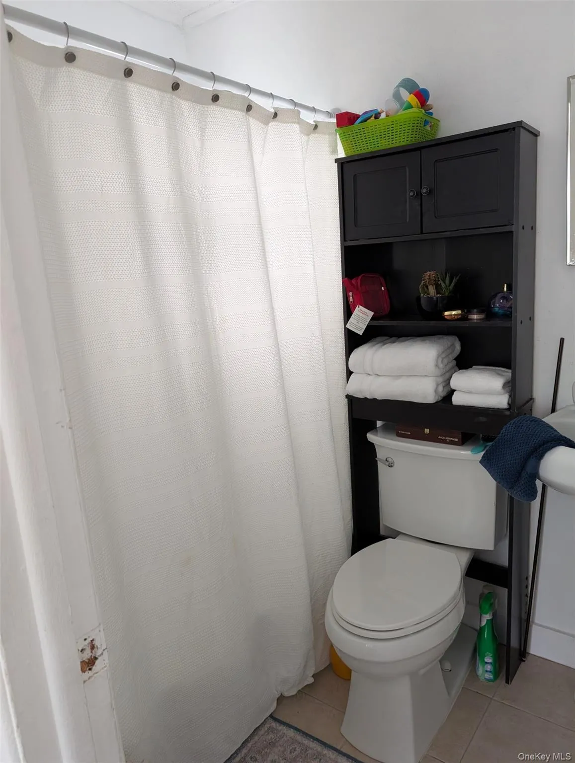 Full bathroom featuring tile patterned flooring, toilet, and a shower with shower curtain Full bathroom featuring tile patterned flooring, toilet, and a shower with shower curtain