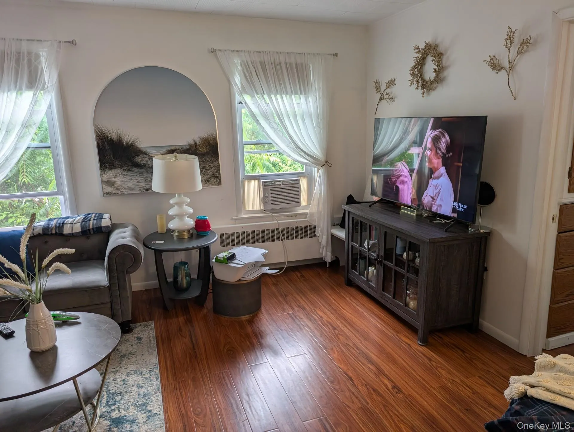 Living room with radiator, wood finished floors, plenty of natural light. Living room with radiator, wood finished floors, plenty of natural light.