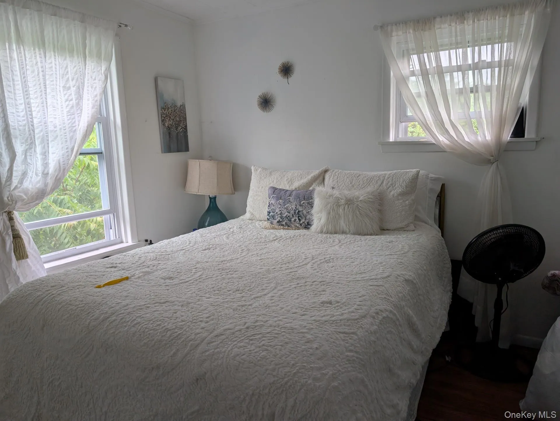 Bedroom with multiple windows, wood finished floors, and ornamental molding Bedroom with multiple windows, wood finished floors, and ornamental molding