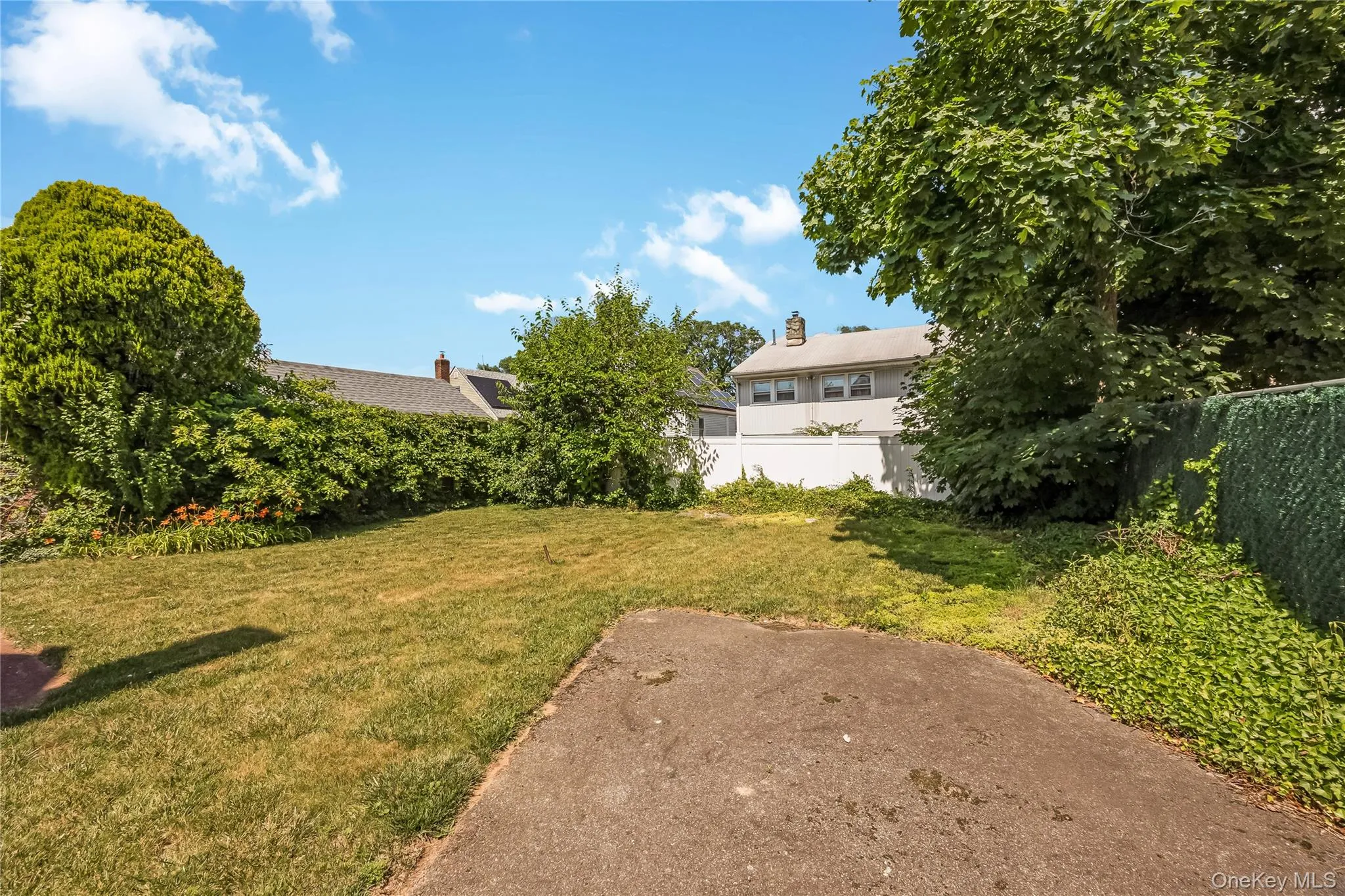 Expansive green lawn with mature trees and established perimeter plantings Expansive green lawn with mature trees and established perimeter plantings