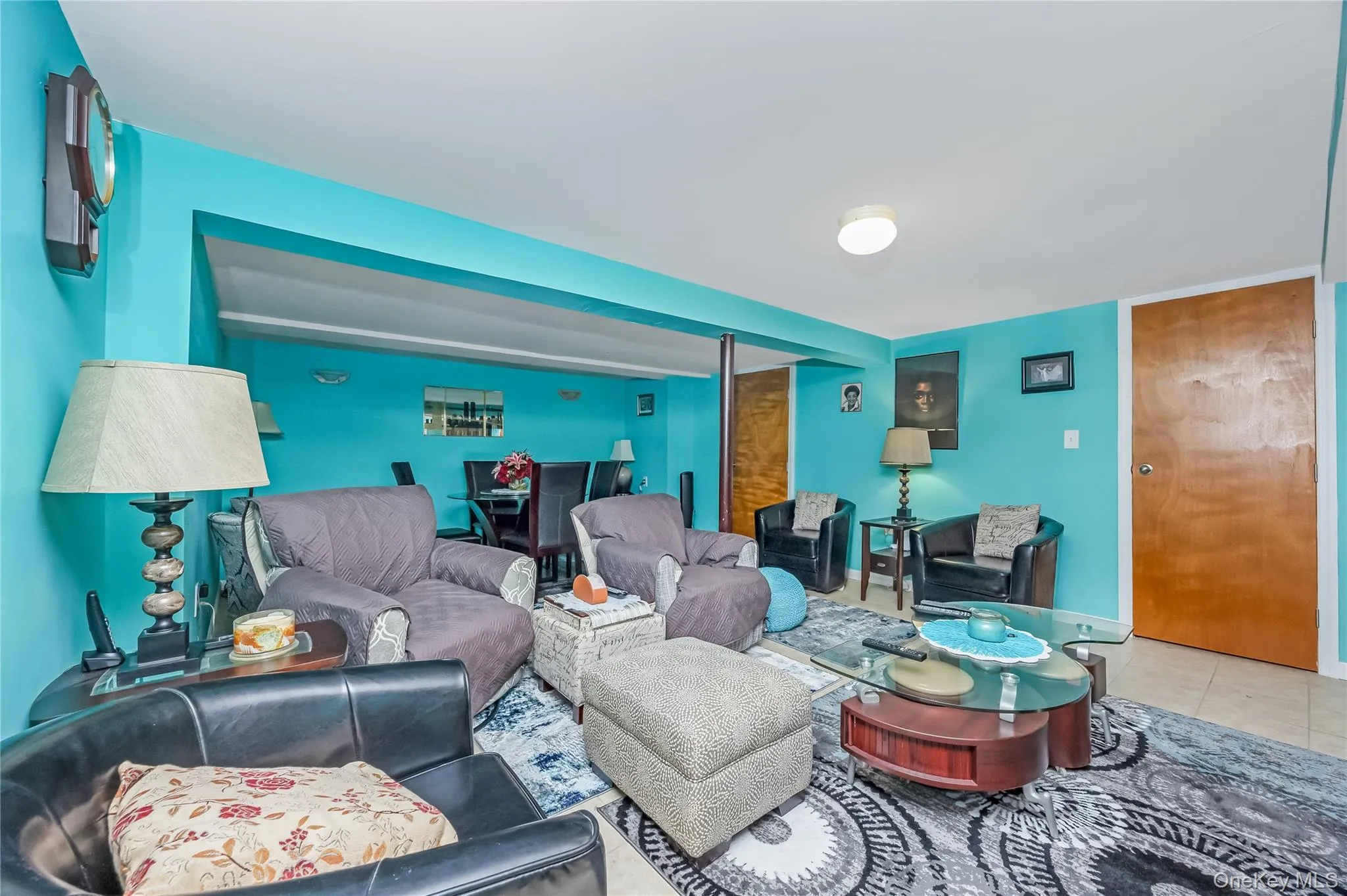 Spacious room with a neutral ceiling, light-colored tile flooring, and a distinct wall color Spacious room with a neutral ceiling, light-colored tile flooring, and a distinct wall color