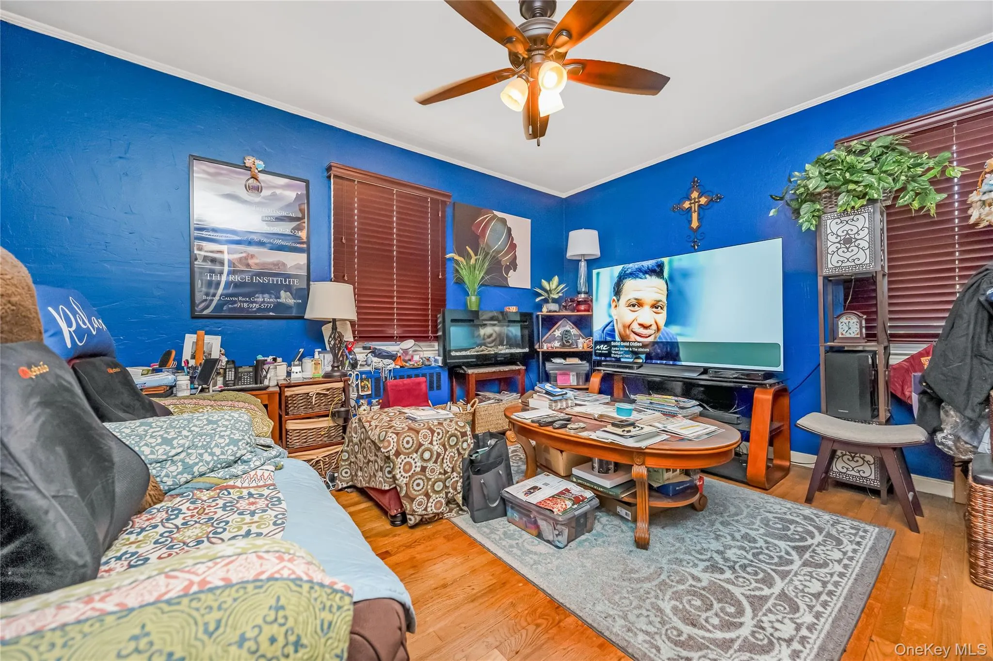 Vibrant room featuring wood-finish flooring, a ceiling fan, and window blinds Vibrant room featuring wood-finish flooring, a ceiling fan, and window blinds