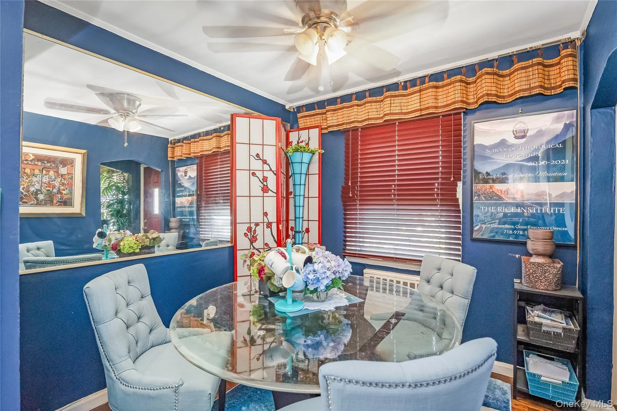 Dining area featuring a clear glass-top table, upholstered chairs with nailhead trim, a ceiling fan, and red horizontal blinds Dining area featuring a clear glass-top table, upholstered chairs with nailhead trim, a ceiling fan, and red horizontal blinds