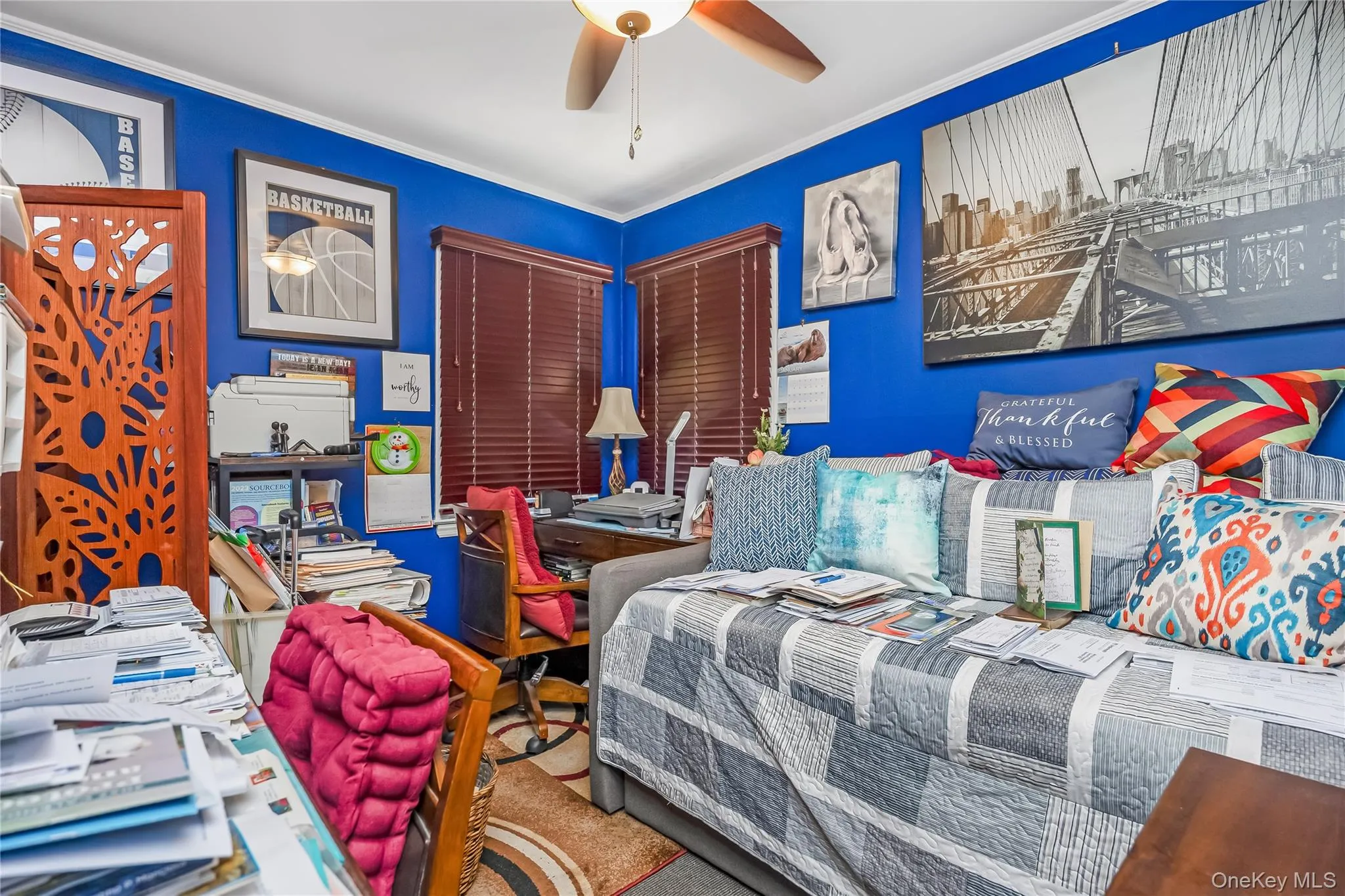 Room featuring blue walls with white trim, a ceiling fan with light fixture, and wood-finish window blinds Room featuring blue walls with white trim, a ceiling fan with light fixture, and wood-finish window blinds