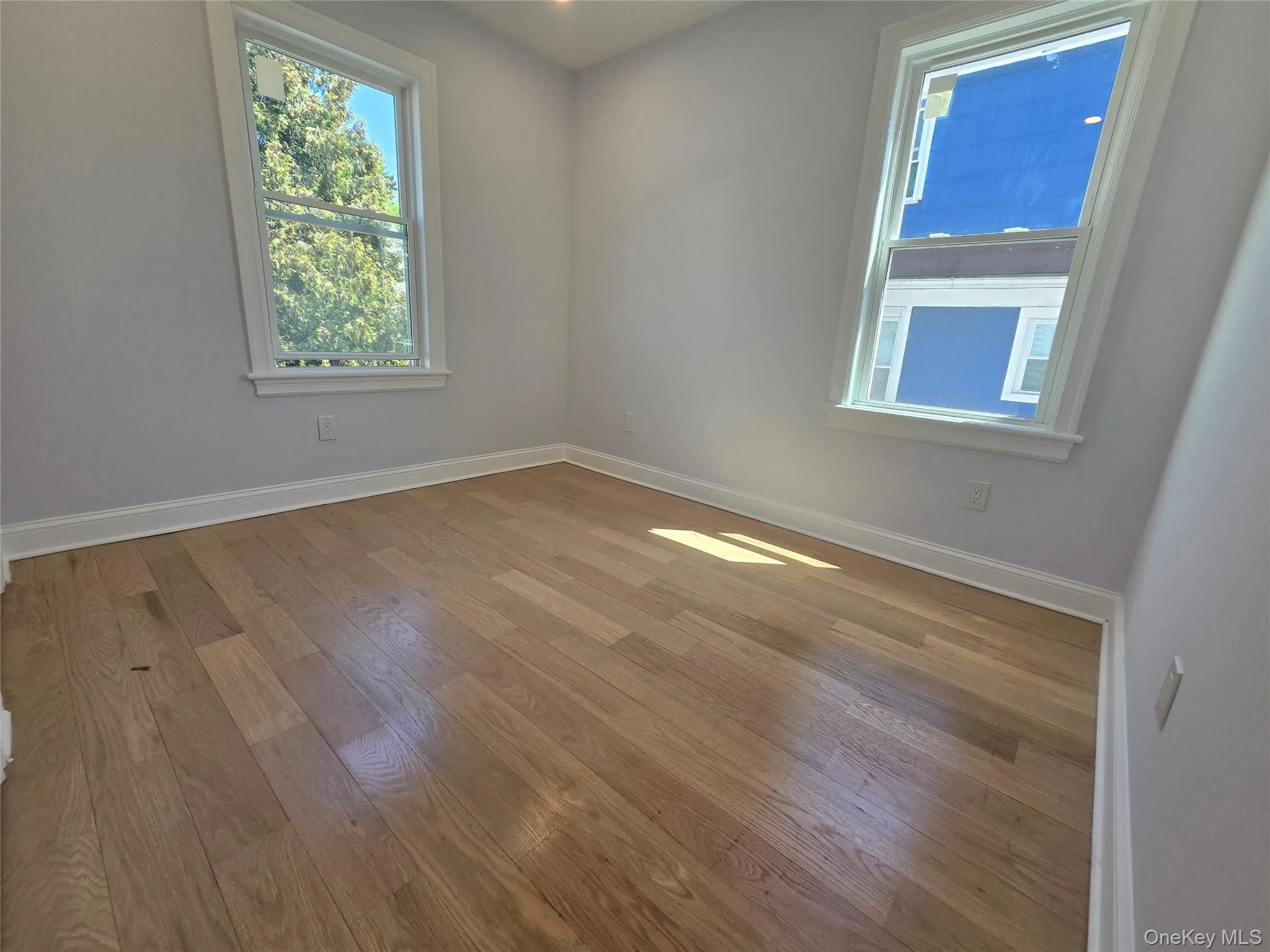 Light wood-finish flooring complemented by white baseboards Light wood-finish flooring complemented by white baseboards