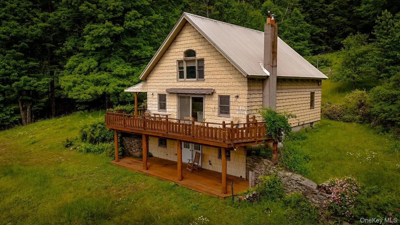 Two-story residence featuring a metal roof and light-colored siding Two-story residence featuring a metal roof and light-colored siding