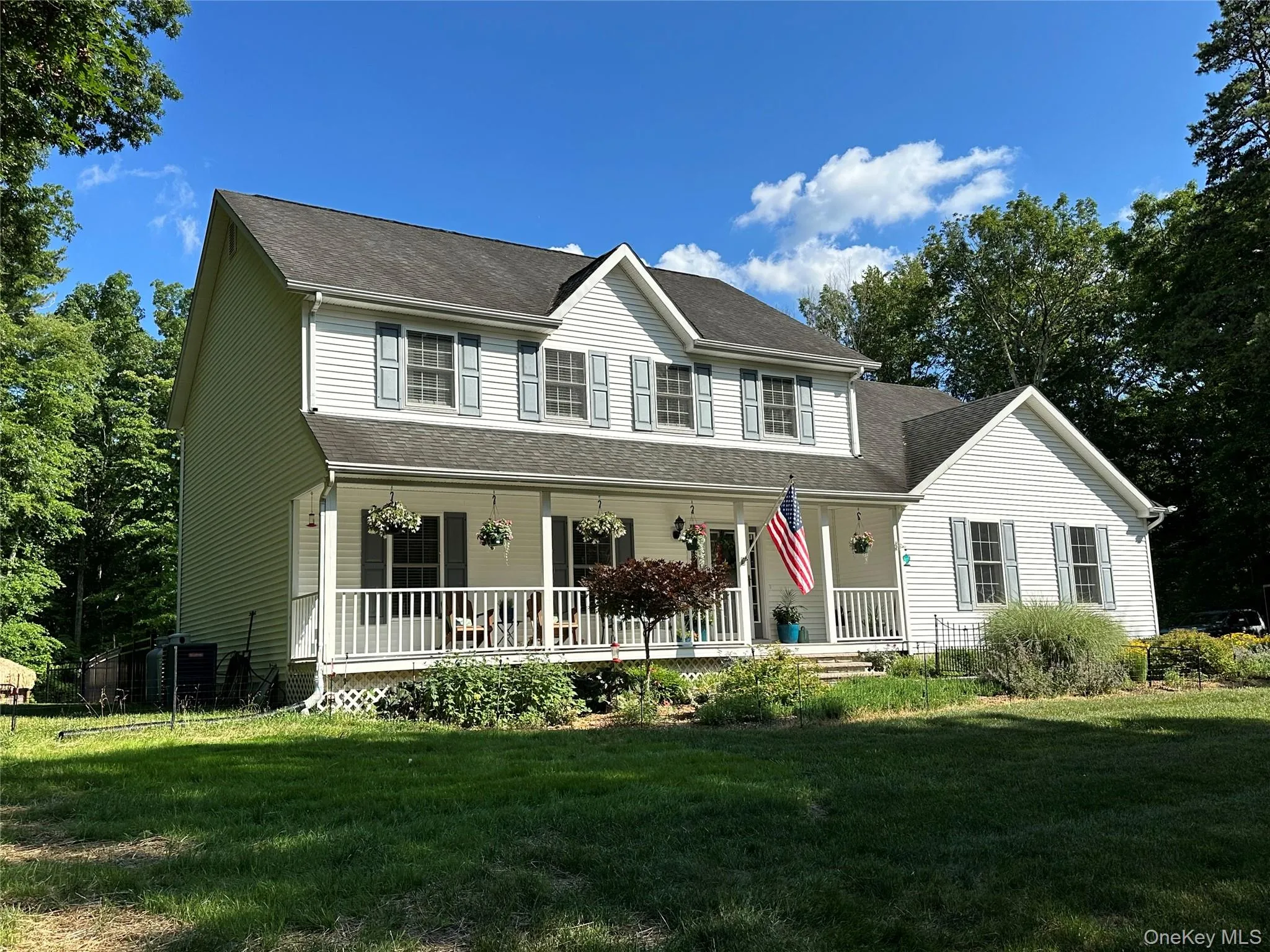 Two-story residence featuring white siding and a covered front porch with white railings Two-story residence featuring white siding and a covered front porch with white railings