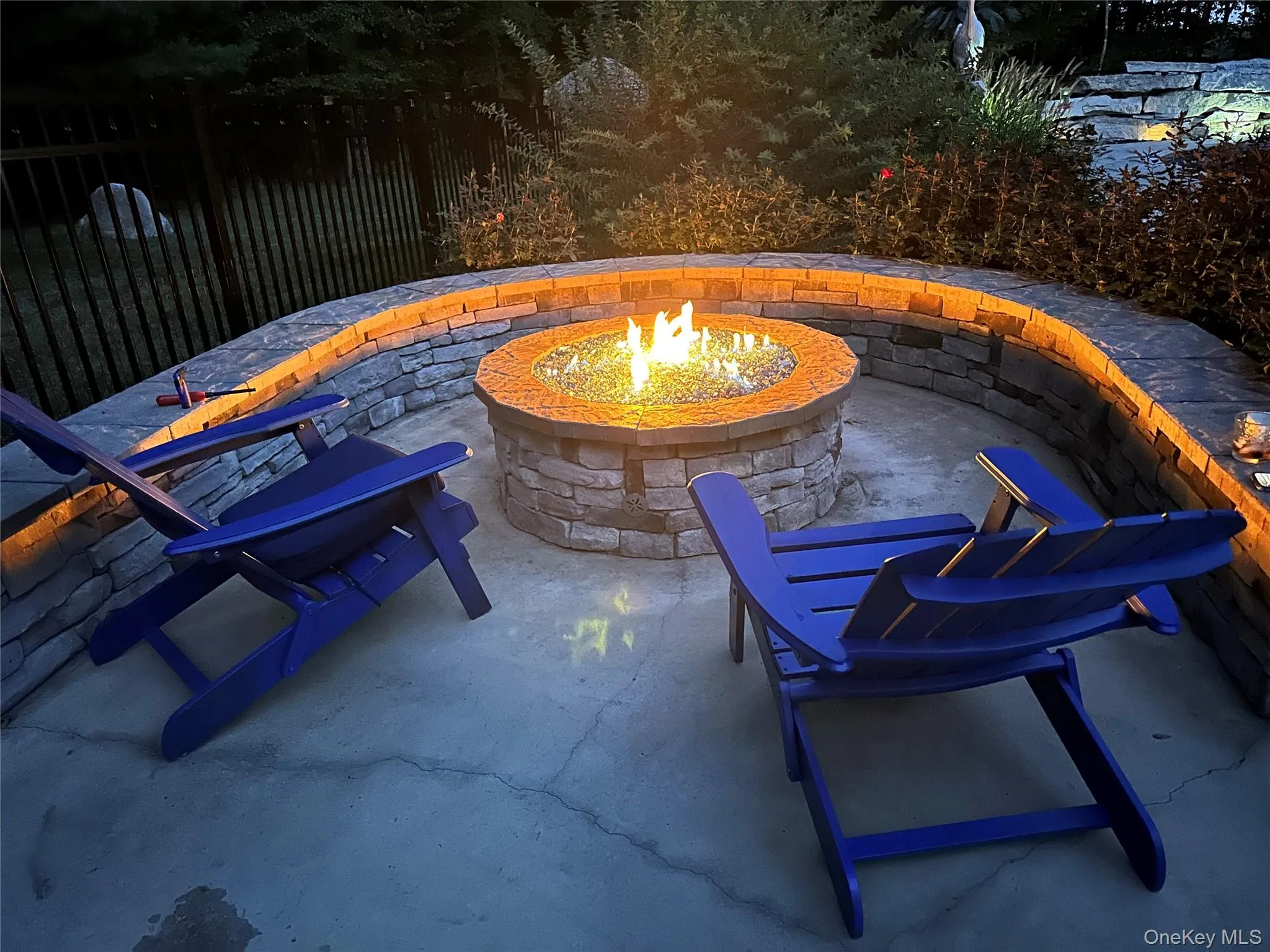 Outdoor patio featuring a stone gas fire pit with a decorative glass media bed Outdoor patio featuring a stone gas fire pit with a decorative glass media bed