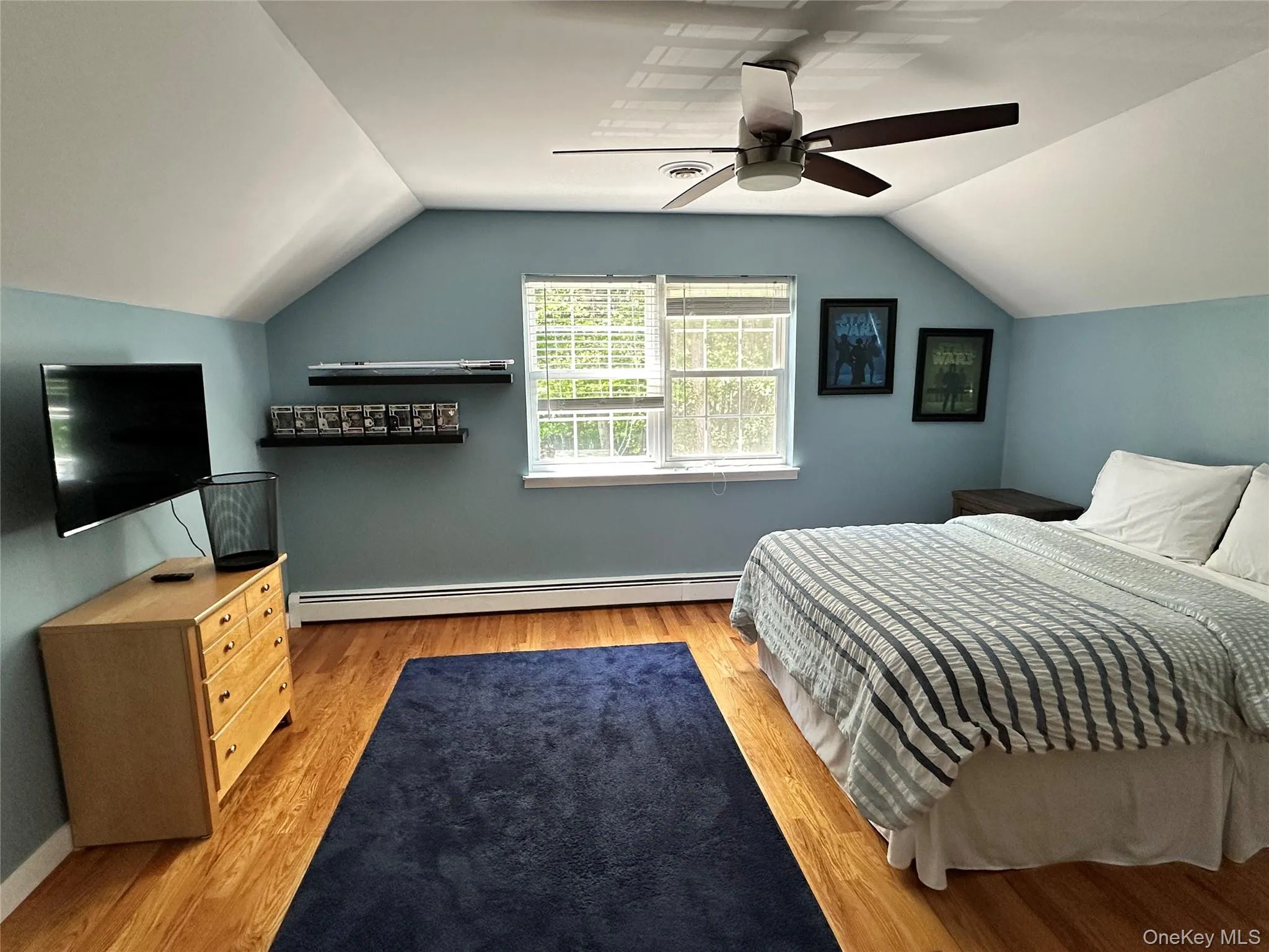 Fourth bedroom with angled ceilings, light wood-finish flooring, and a ceiling fan Fourth bedroom with angled ceilings, light wood-finish flooring, and a ceiling fan