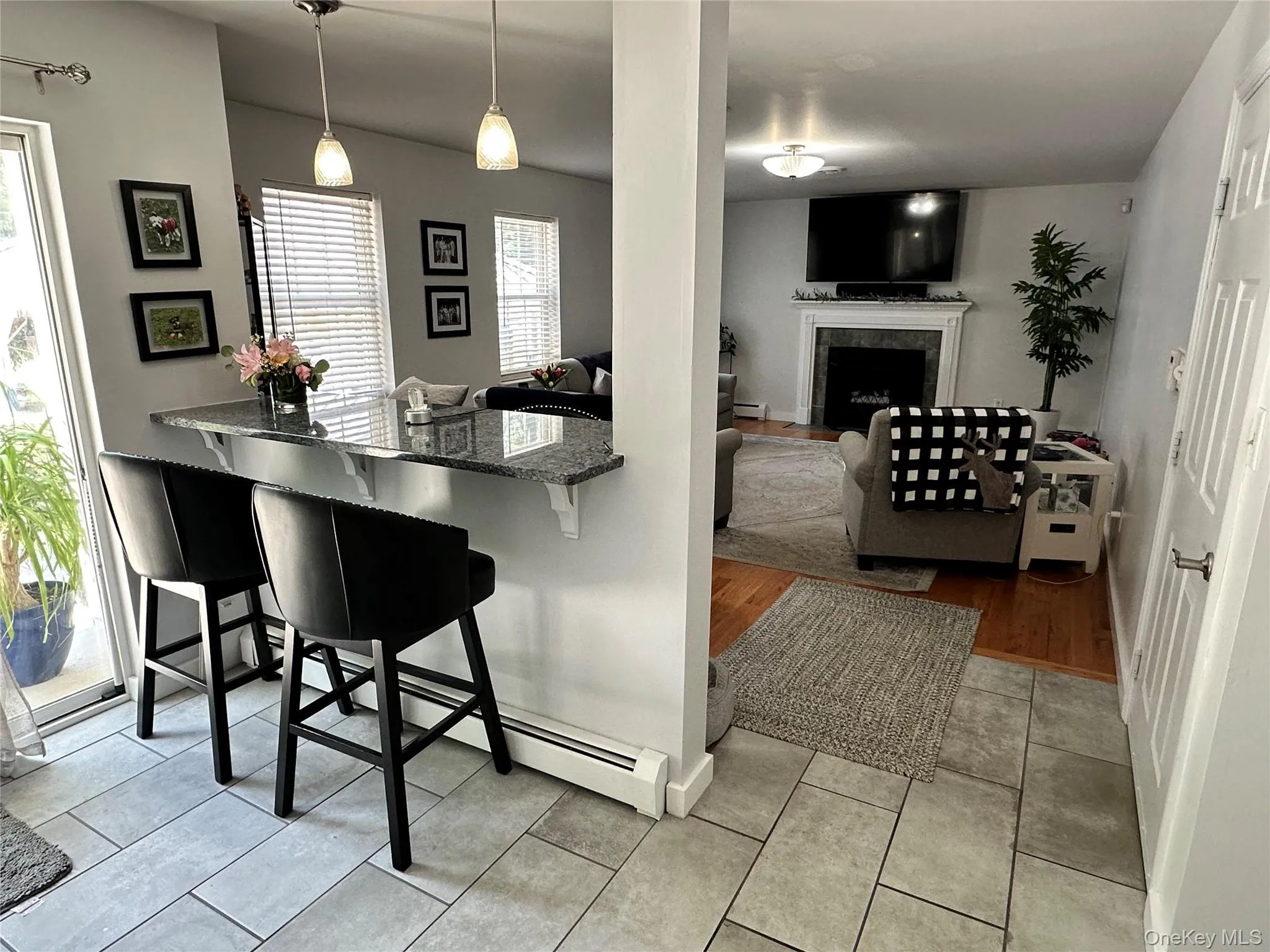 Kitchen pass-through with a granite countertop and pendant lighting leading into the Living Room Kitchen pass-through with a granite countertop and pendant lighting leading into the Living Room