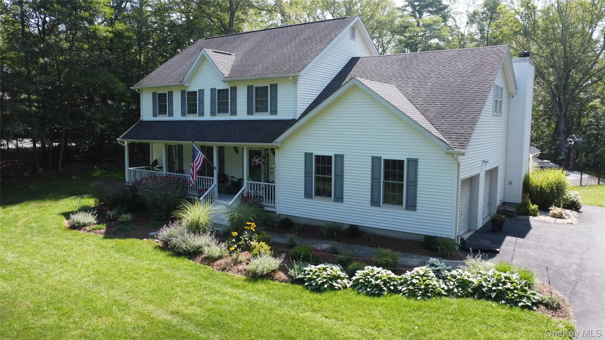Two-story home with white siding, a covered front porch, and a two-car garage Two-story home with white siding, a covered front porch, and a two-car garage