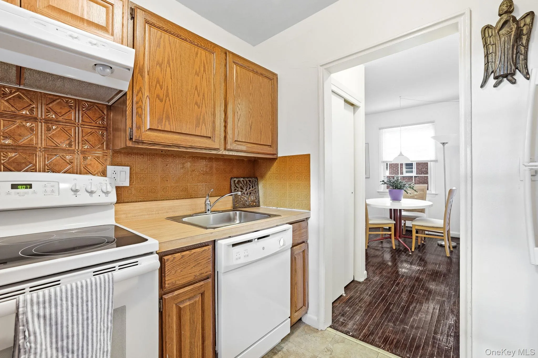 The range has 5 burners and there is a full-sized dishwasher. This view shows the adjacent dining area The range has 5 burners and there is a full-sized dishwasher. This view shows the adjacent dining area