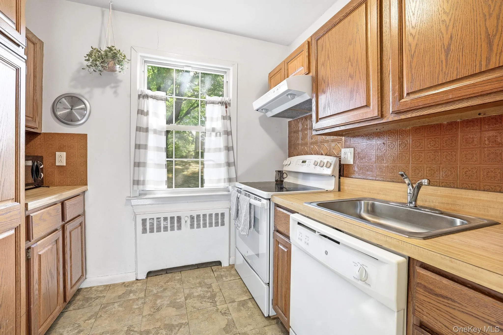 The kitchen has a window that overlooks the back courtyard and gardens The kitchen has a window that overlooks the back courtyard and gardens