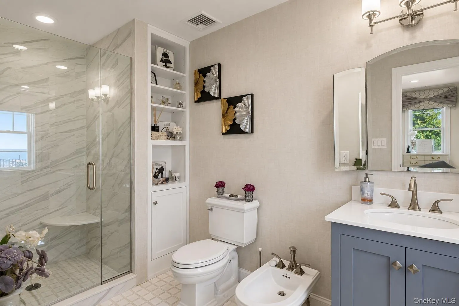 Spacious bathroom featuring a glass-enclosed shower with a built-in bench, light-toned wall tiling, and a window Spacious bathroom featuring a glass-enclosed shower with a built-in bench, light-toned wall tiling, and a window