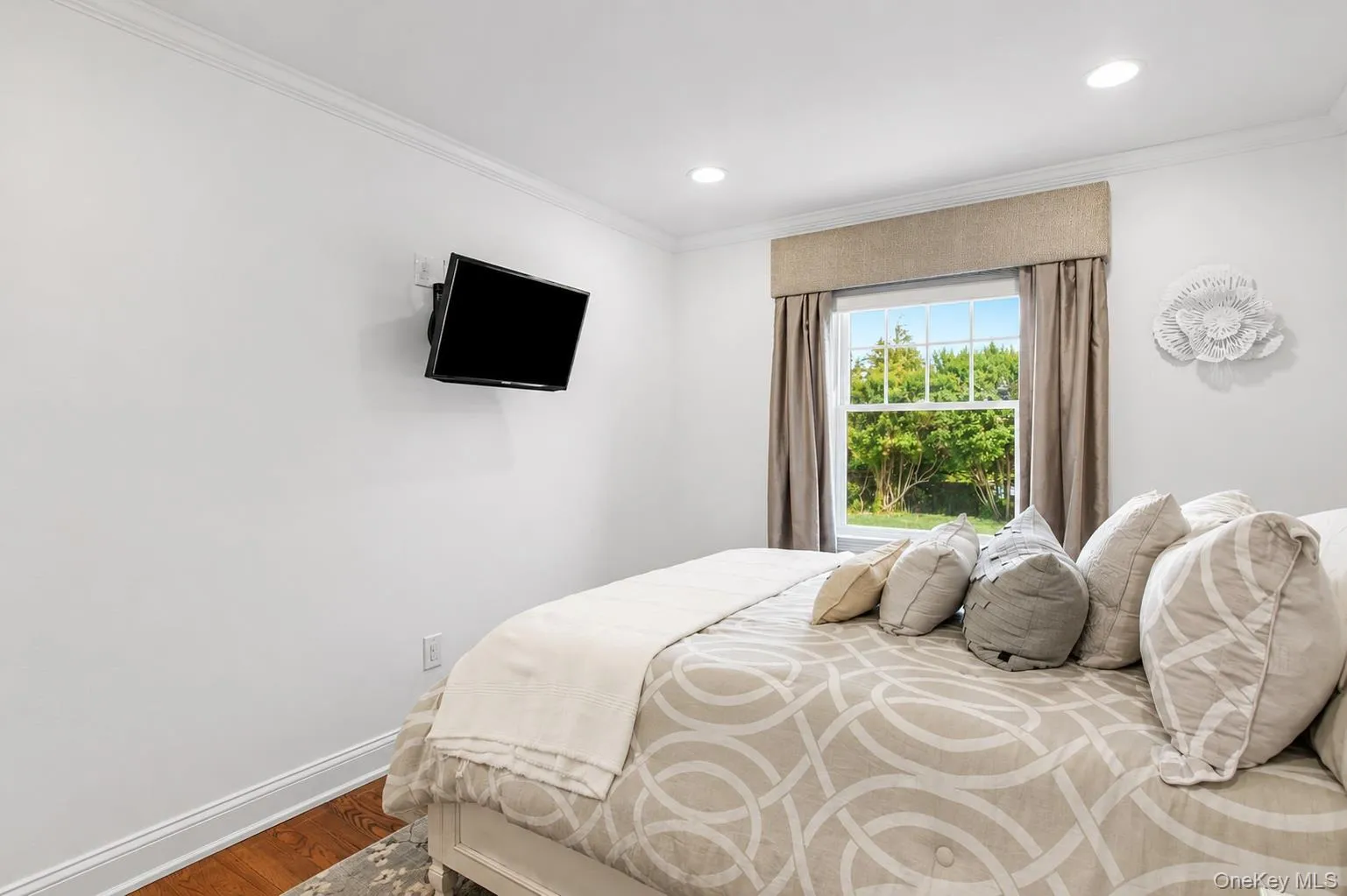 Bedroom featuring a large window, recessed lighting, crown molding, and wood flooring Bedroom featuring a large window, recessed lighting, crown molding, and wood flooring