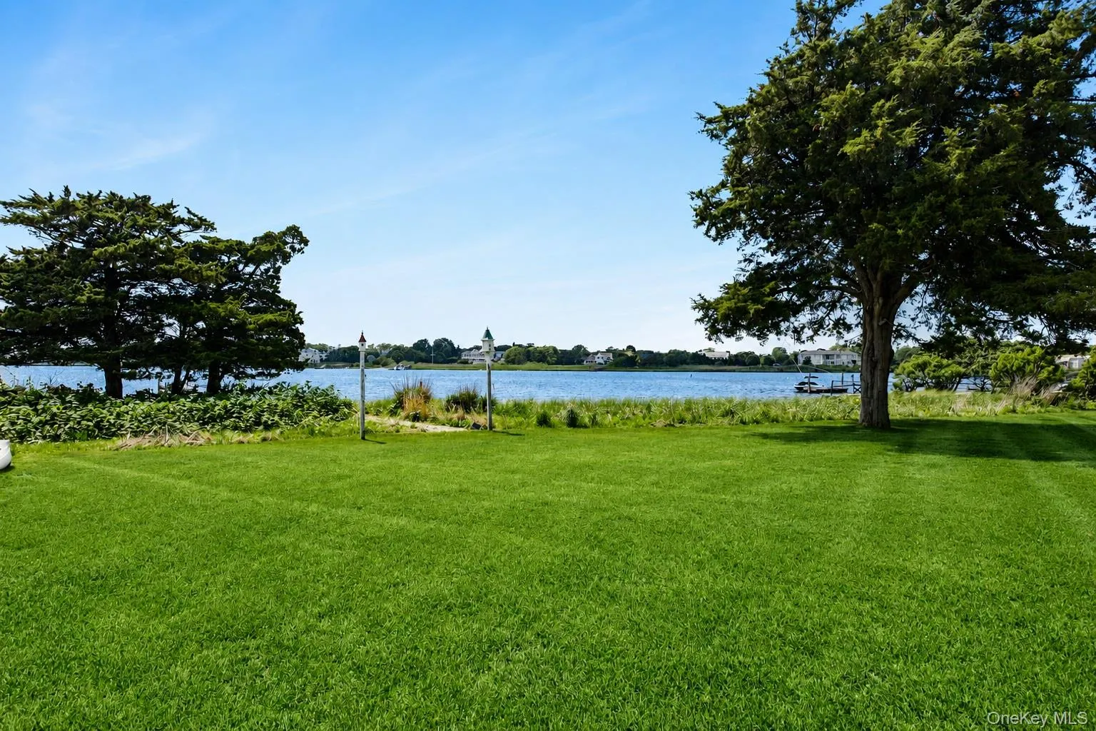 Expansive lawn with mature trees and waterfront access Expansive lawn with mature trees and waterfront access