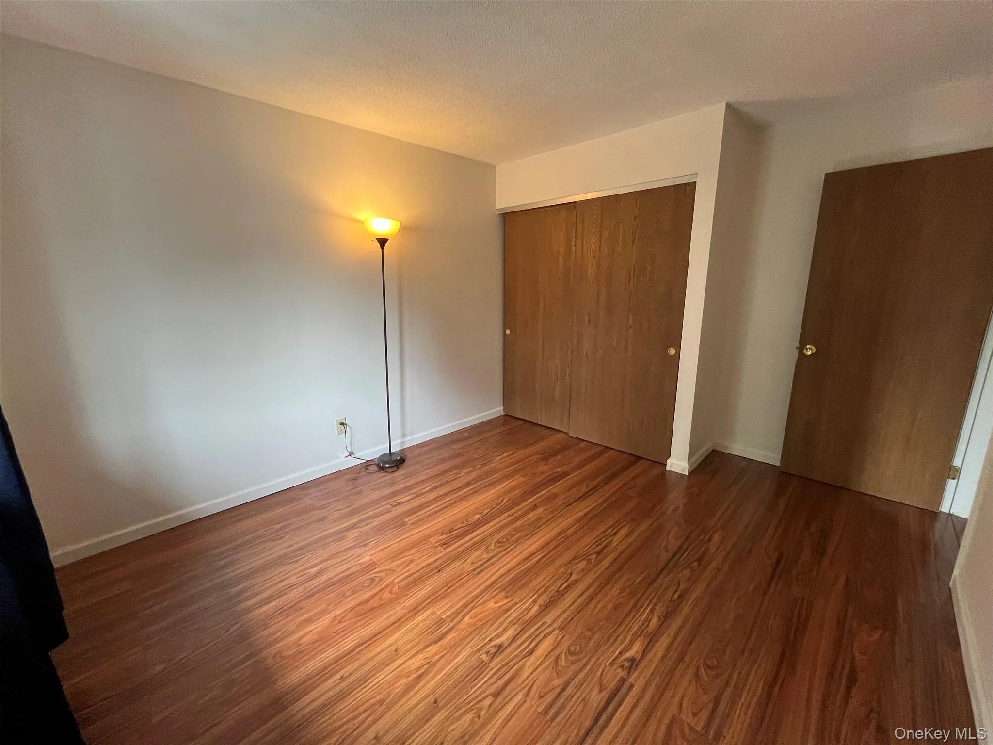 Unfurnished bedroom with wood finished floors and a closet Unfurnished bedroom with wood finished floors and a closet