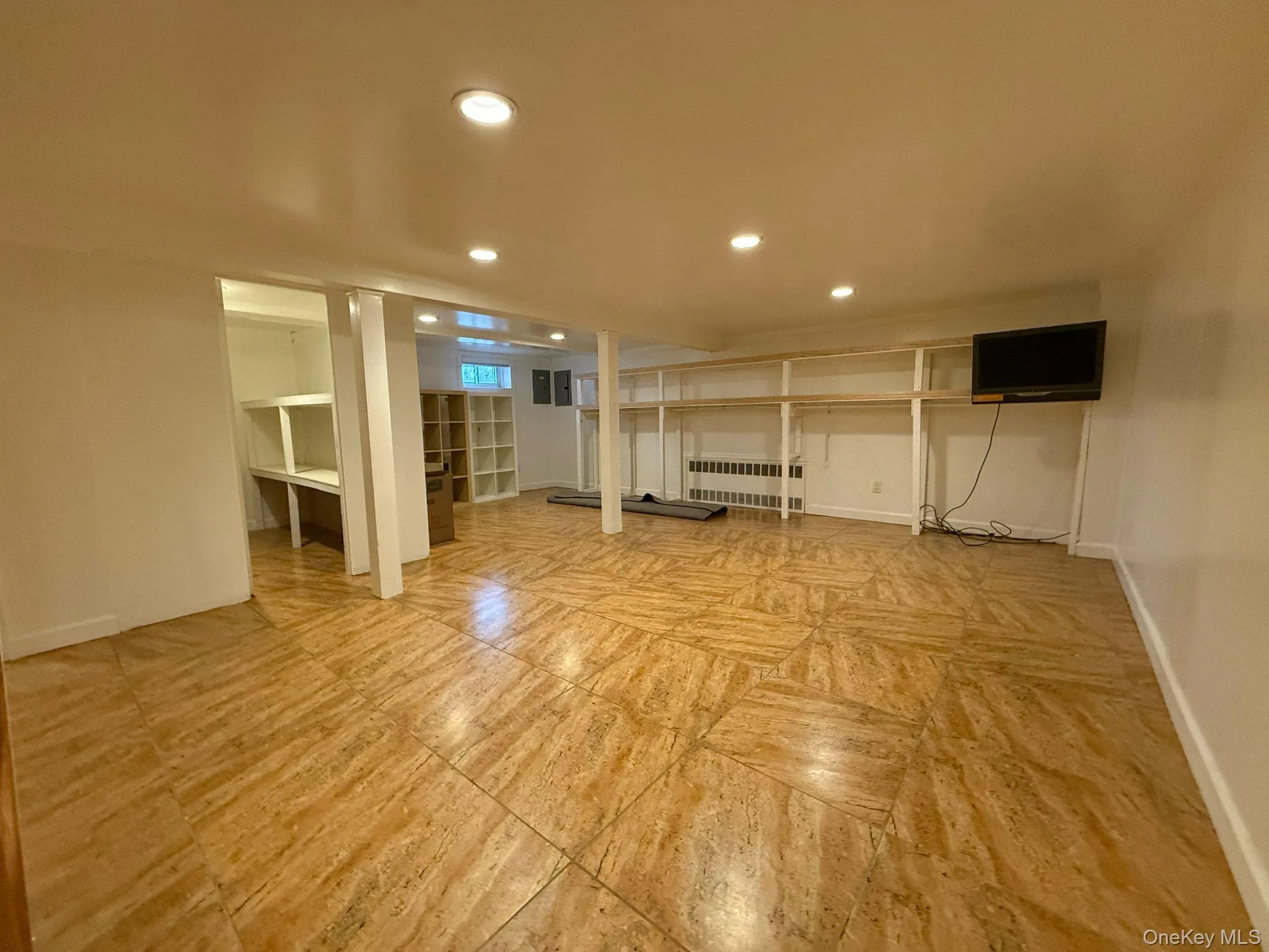 Finished below grade area with radiator, baseboards, and recessed lighting Finished below grade area with radiator, baseboards, and recessed lighting