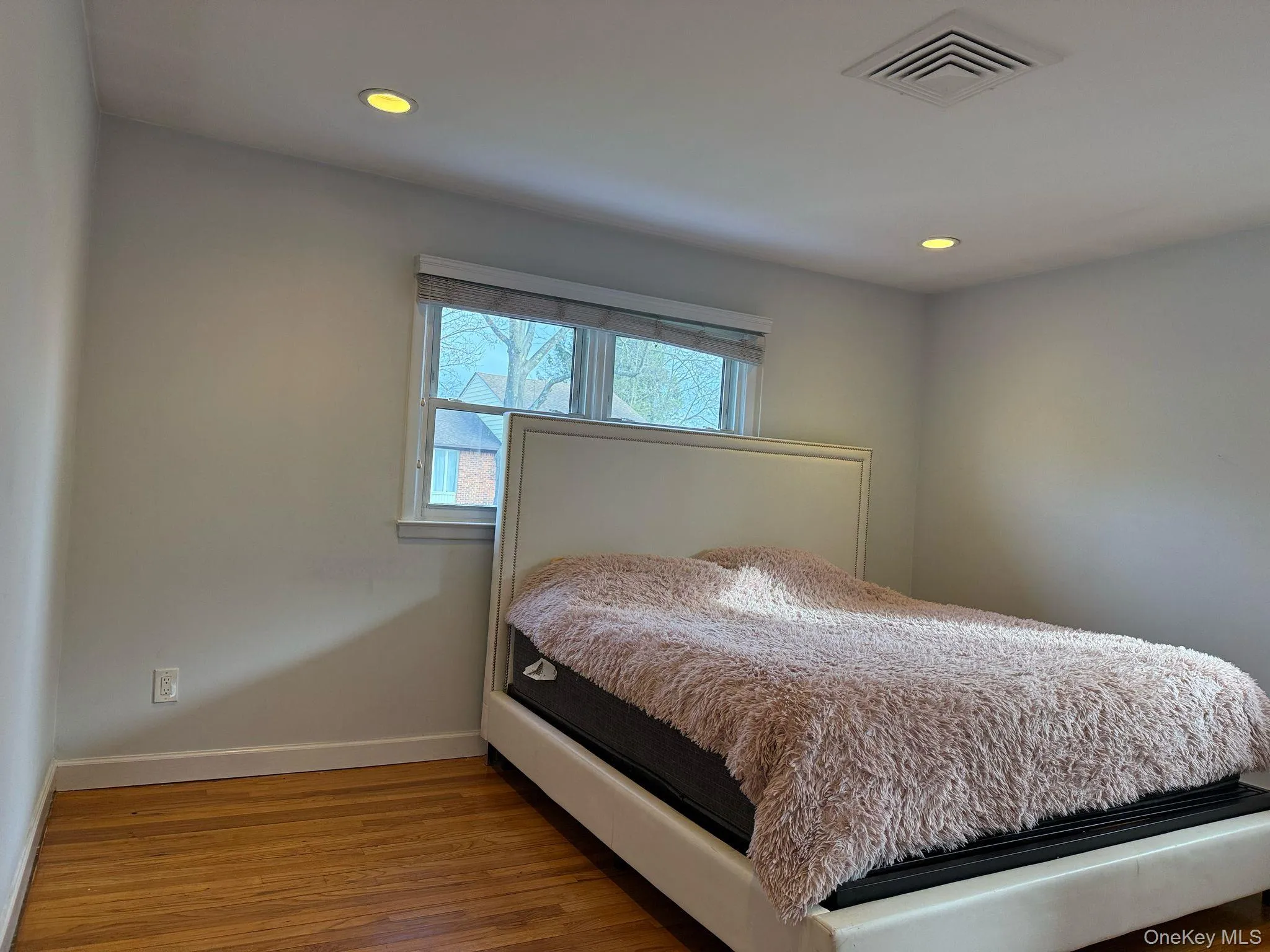 Bedroom with baseboards, visible vents, wood finished floors, and recessed lighting Bedroom with baseboards, visible vents, wood finished floors, and recessed lighting