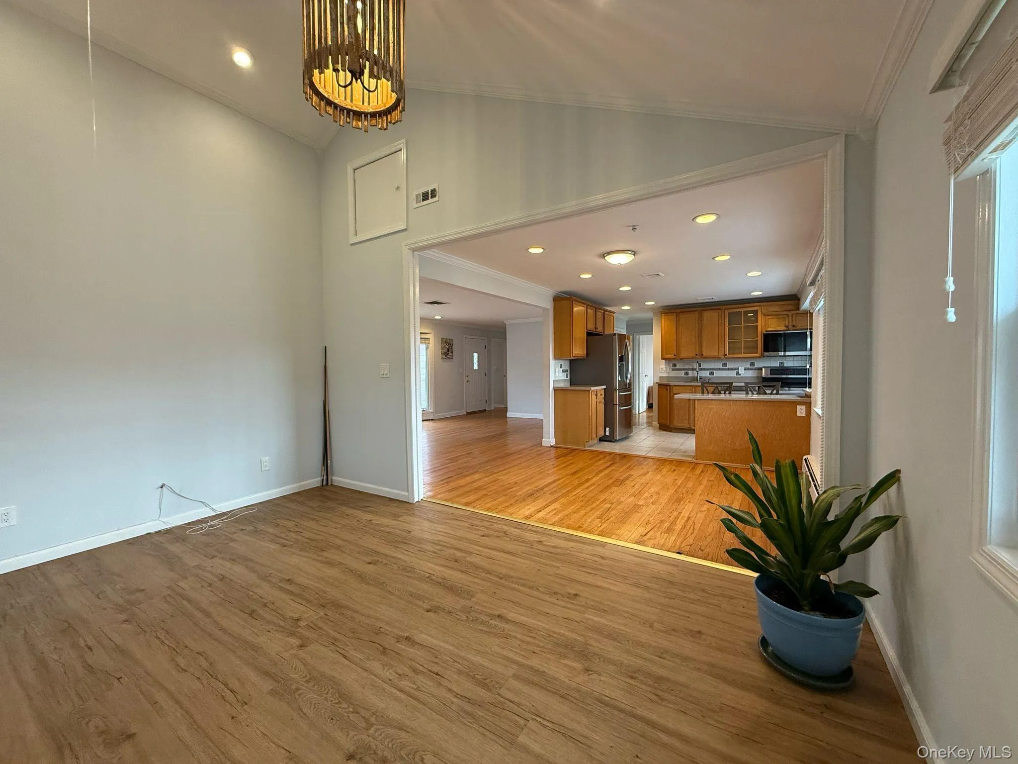 Unfurnished living room with recessed lighting, ornamental molding, baseboards, visible vents, and light wood-style flooring Unfurnished living room with recessed lighting, ornamental molding, baseboards, visible vents, and light wood-style flooring