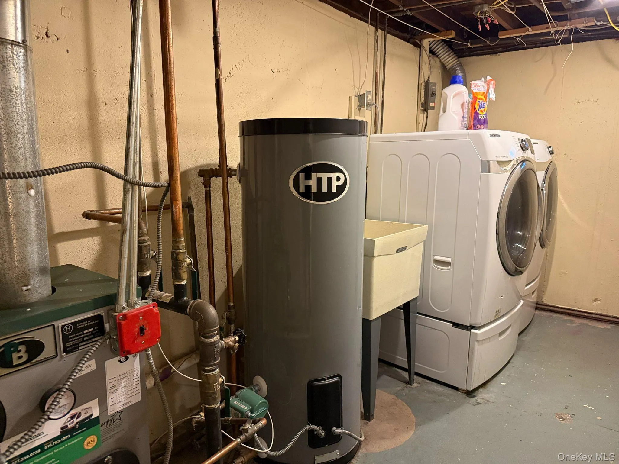 Washroom with water heater, washing machine and clothes dryer, and laundry area Washroom with water heater, washing machine and clothes dryer, and laundry area