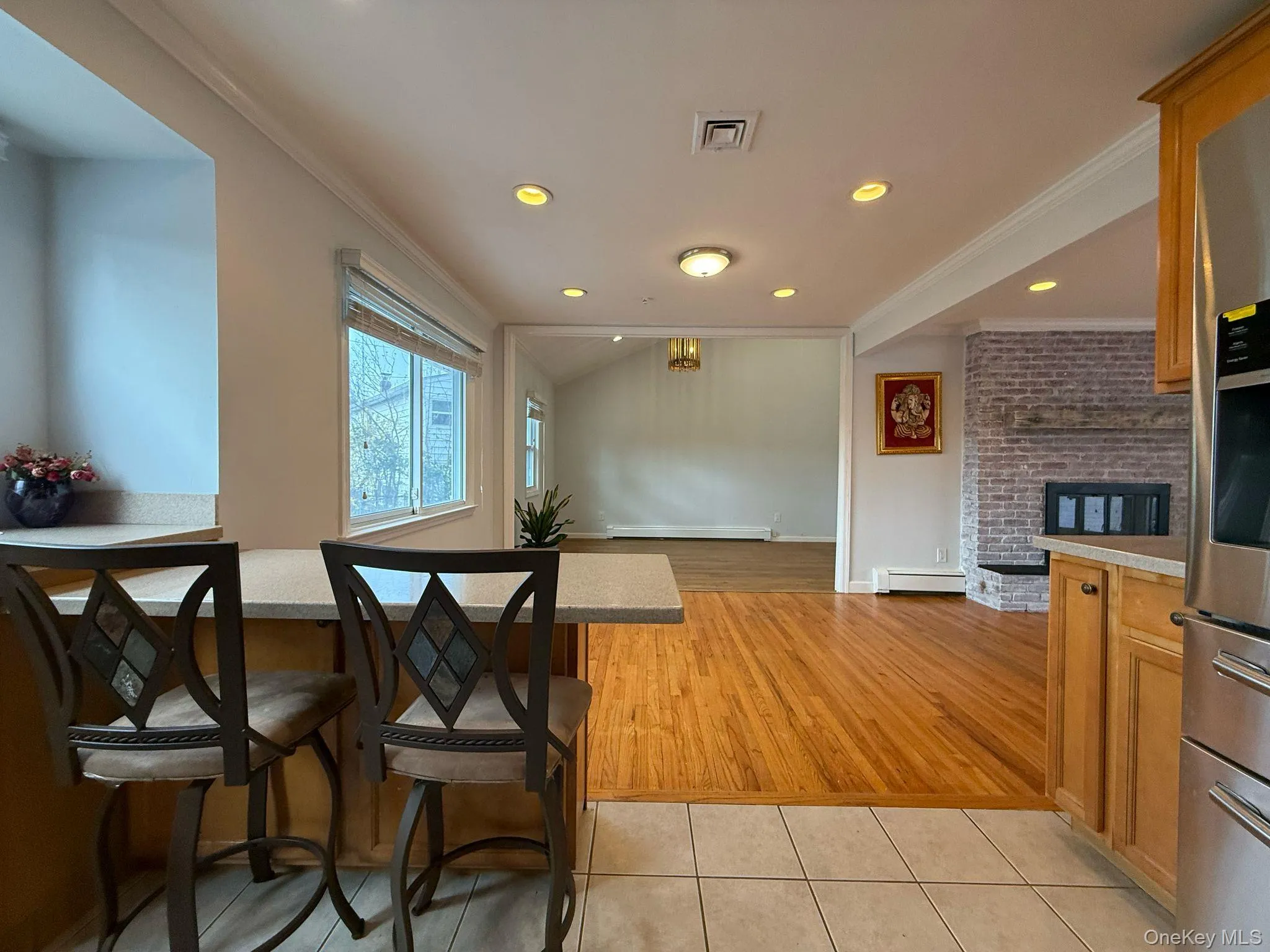 Kitchen featuring a baseboard radiator, light tile patterned floors, crown molding, and visible vents Kitchen featuring a baseboard radiator, light tile patterned floors, crown molding, and visible vents