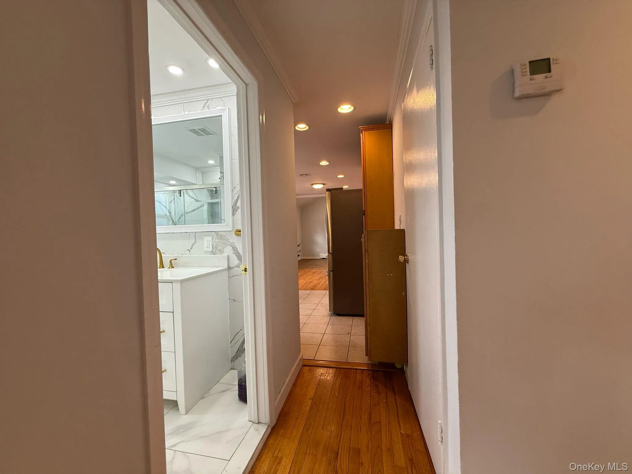 Hall featuring visible vents, light wood-style flooring, and recessed lighting Hall featuring visible vents, light wood-style flooring, and recessed lighting