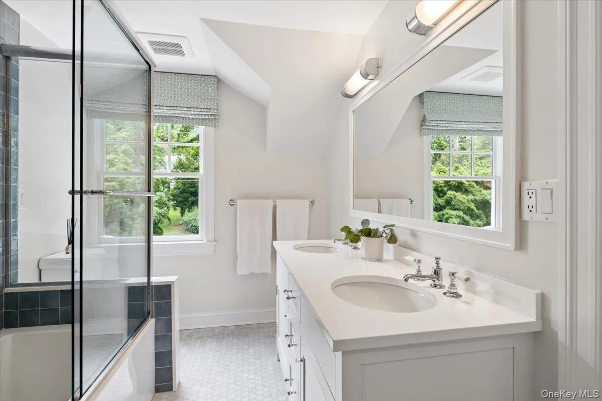 White double vanity with integrated sinks, chrome fixtures, and a framed mirror White double vanity with integrated sinks, chrome fixtures, and a framed mirror