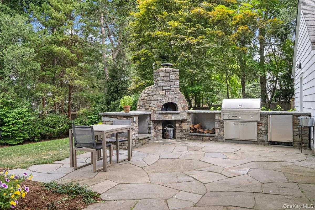 Beautifully crafted flagstone patio featuring a built-in stone pizza oven, integrated outdoor grill, and stainless steel outdoor refrigerator Beautifully crafted flagstone patio featuring a built-in stone pizza oven, integrated outdoor grill, and stainless steel outdoor refrigerator