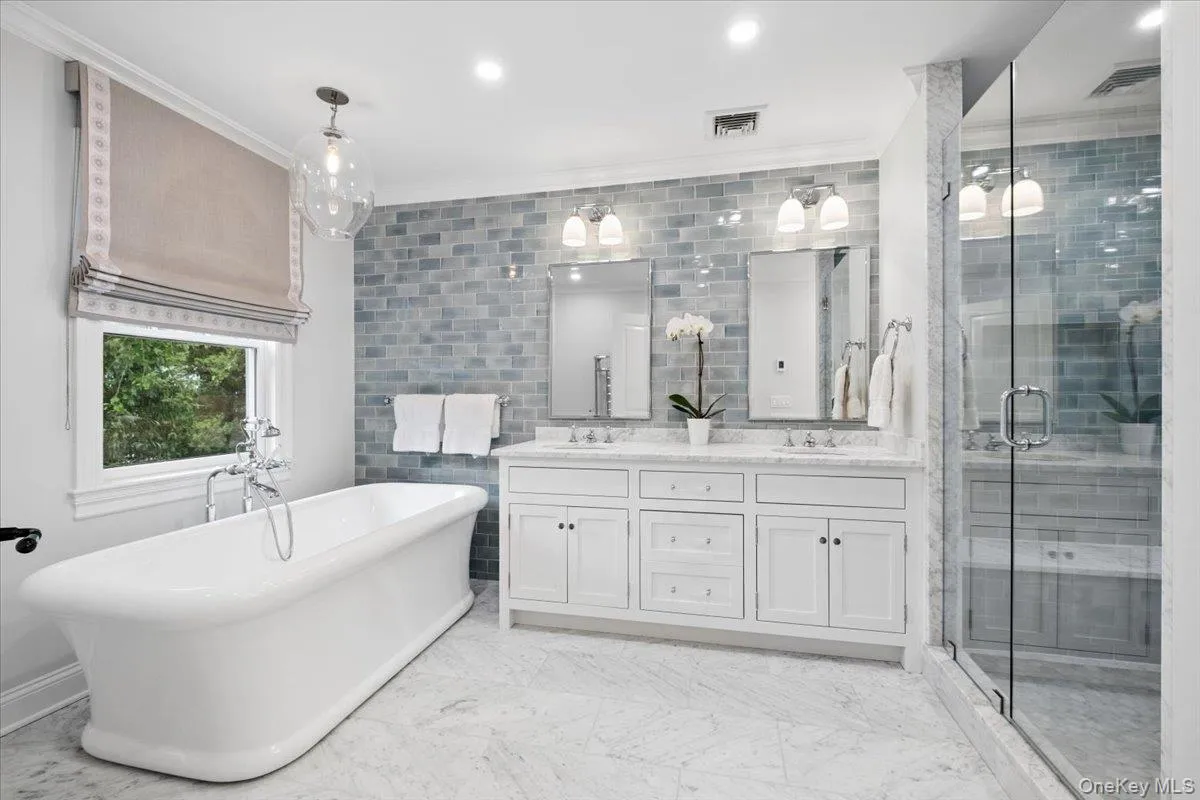 Stunning primary bath/spa freestanding soaking tub with floor-mounted faucet, beautiful cabinetry and an oversized shower Stunning primary bath/spa freestanding soaking tub with floor-mounted faucet, beautiful cabinetry and an oversized shower