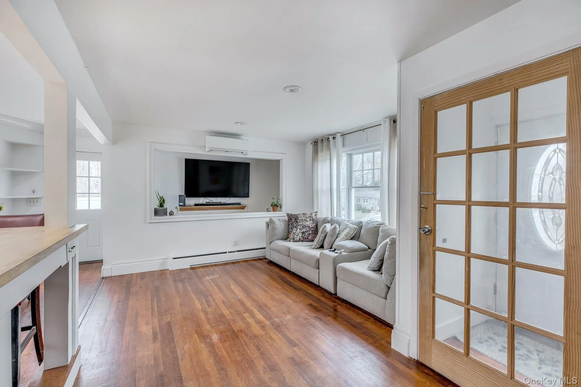 Living area featuring wood-finish flooring, recessed lighting, and white trim Living area featuring wood-finish flooring, recessed lighting, and white trim