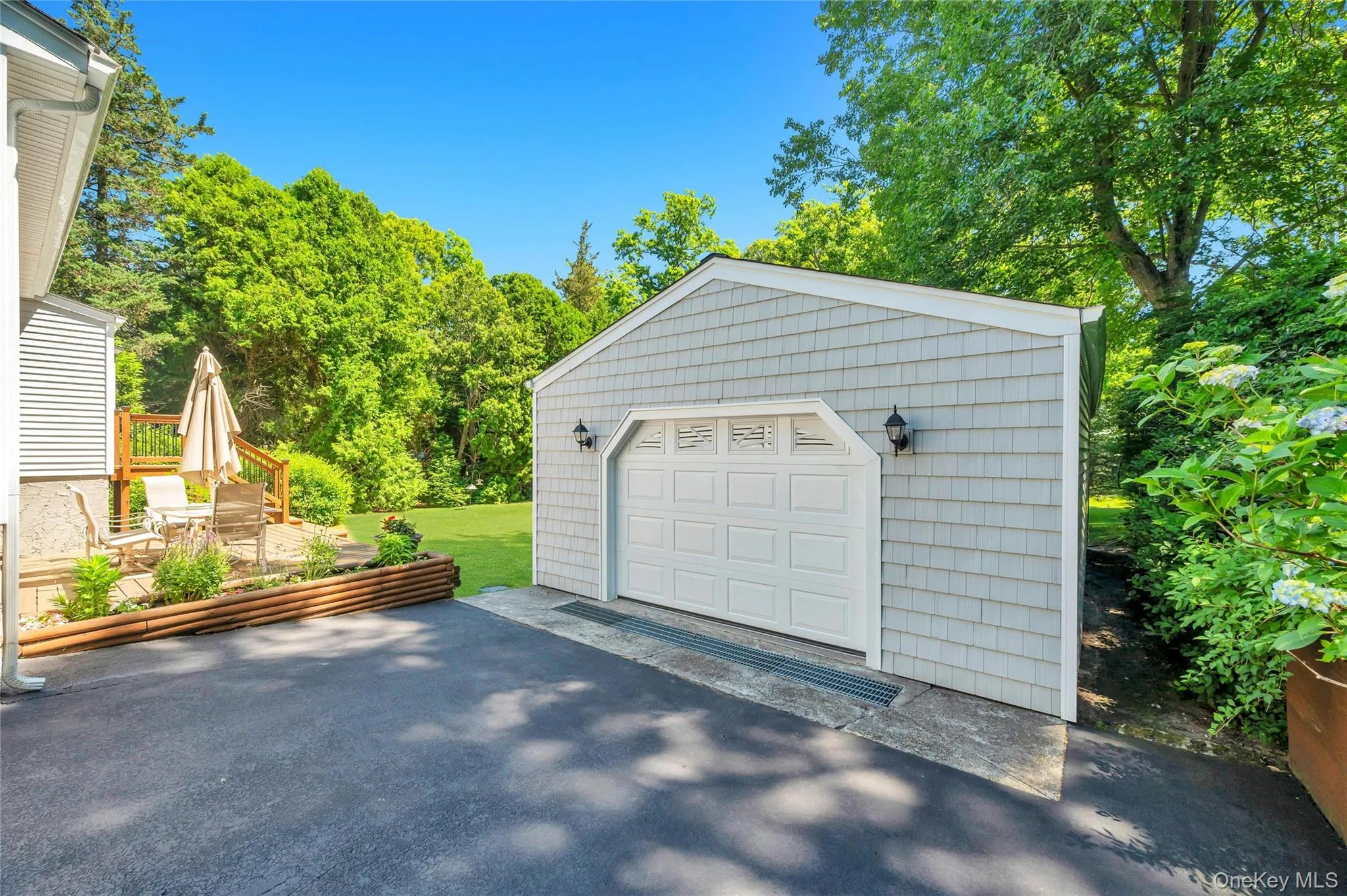 Detached garage with vinyl siding and an asphalt driveway Detached garage with vinyl siding and an asphalt driveway